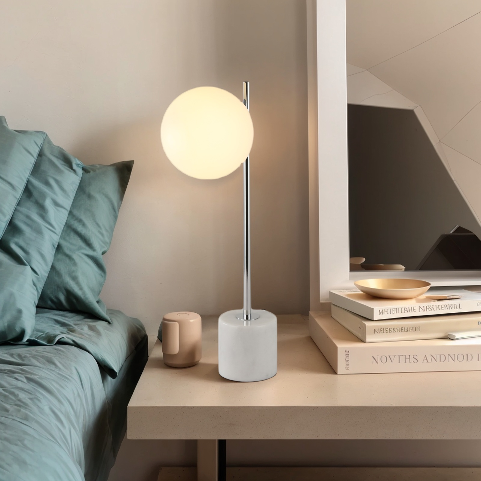 Una lámpara de globo blanca sobre una mesa con un libro y una taza.