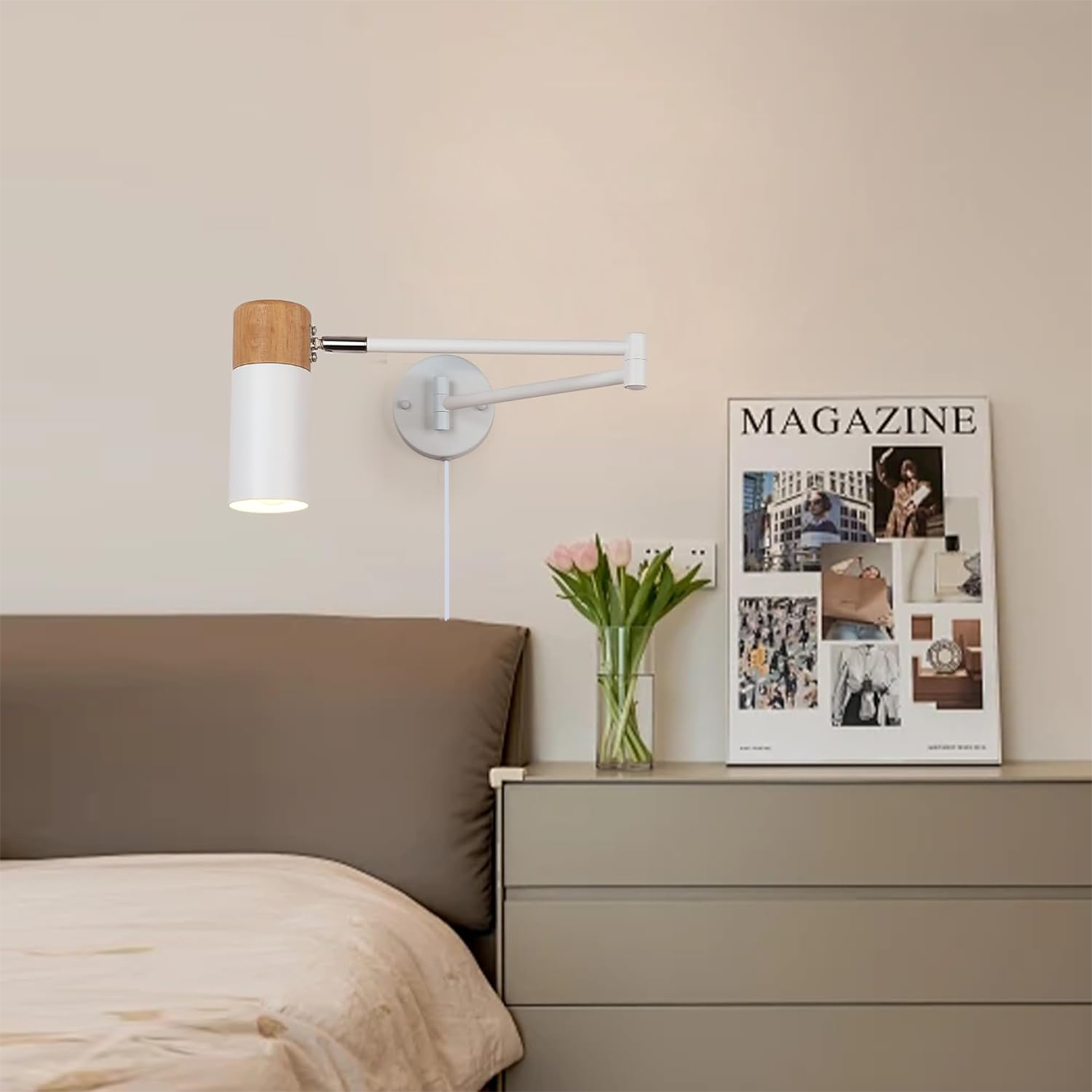 Lámpara de pared con tapa de madera y base blanca. Una revista y una cama en el fondo.