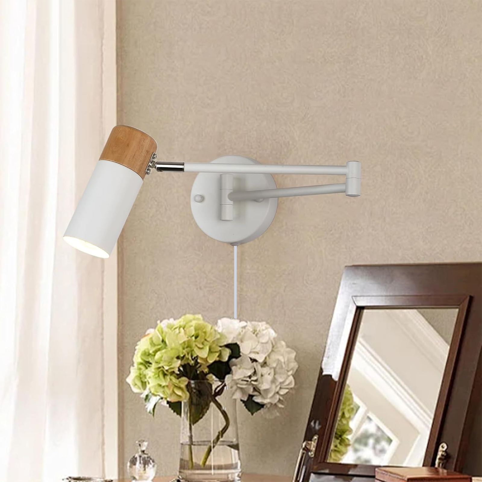 Un aplique de pared blanco y tono madera está montado en una pared beige. Un arreglo floral está sobre una mesa.