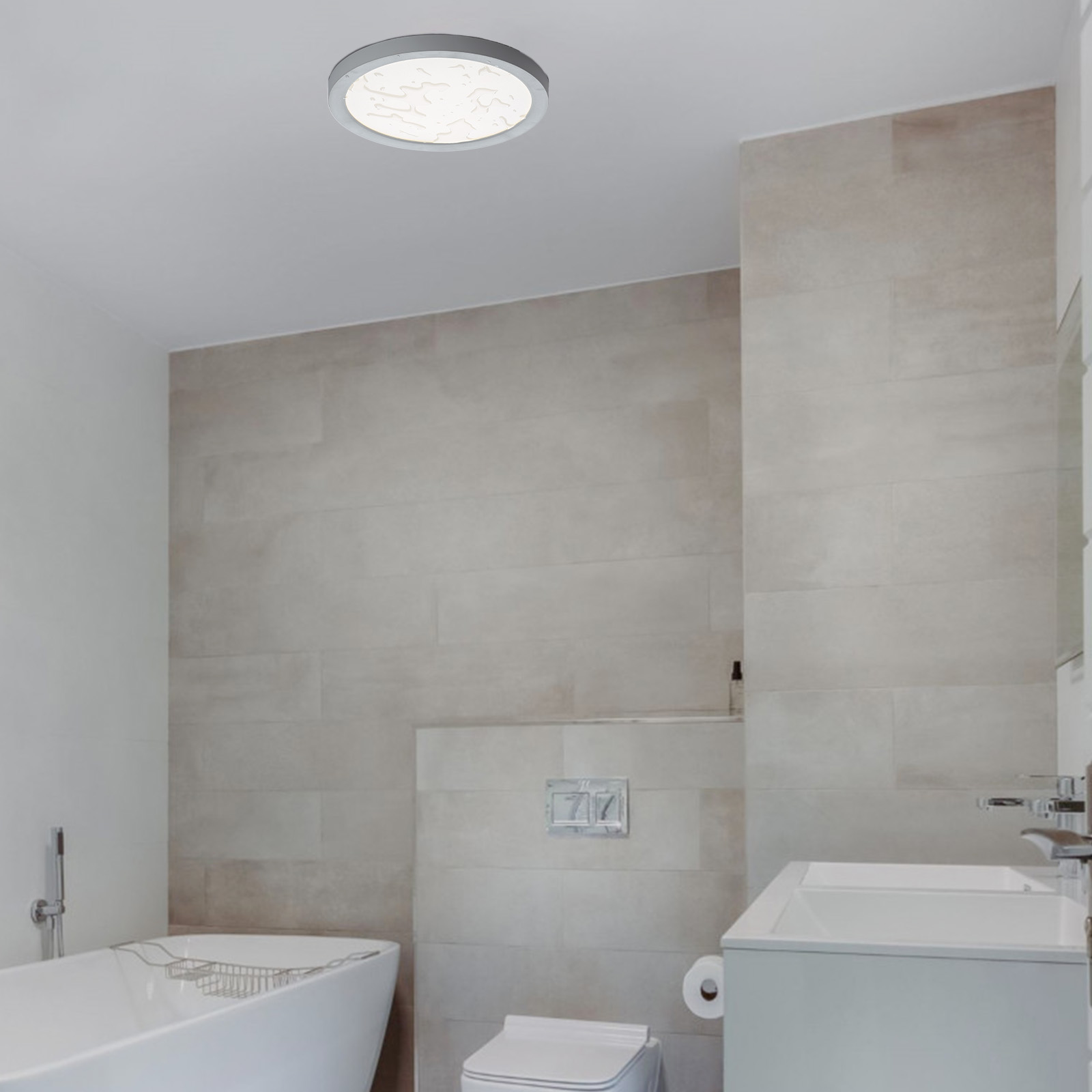 Un baño con una luz de techo redonda. Lavabo blanco, inodoro y azulejos beige presentes.