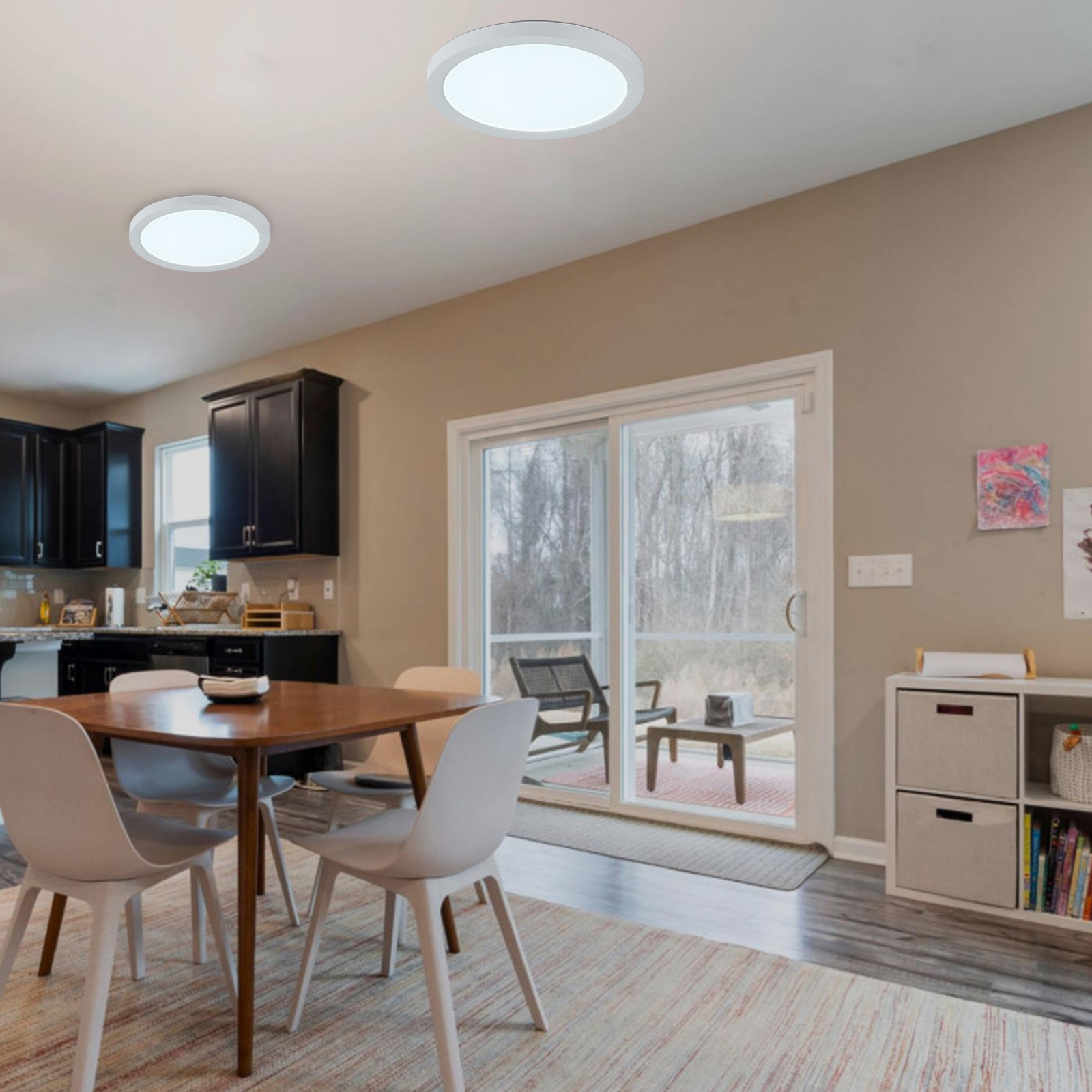 Toma interior de un comedor. Dos luces de techo están encendidas. Una mesa con sillas está en primer plano.