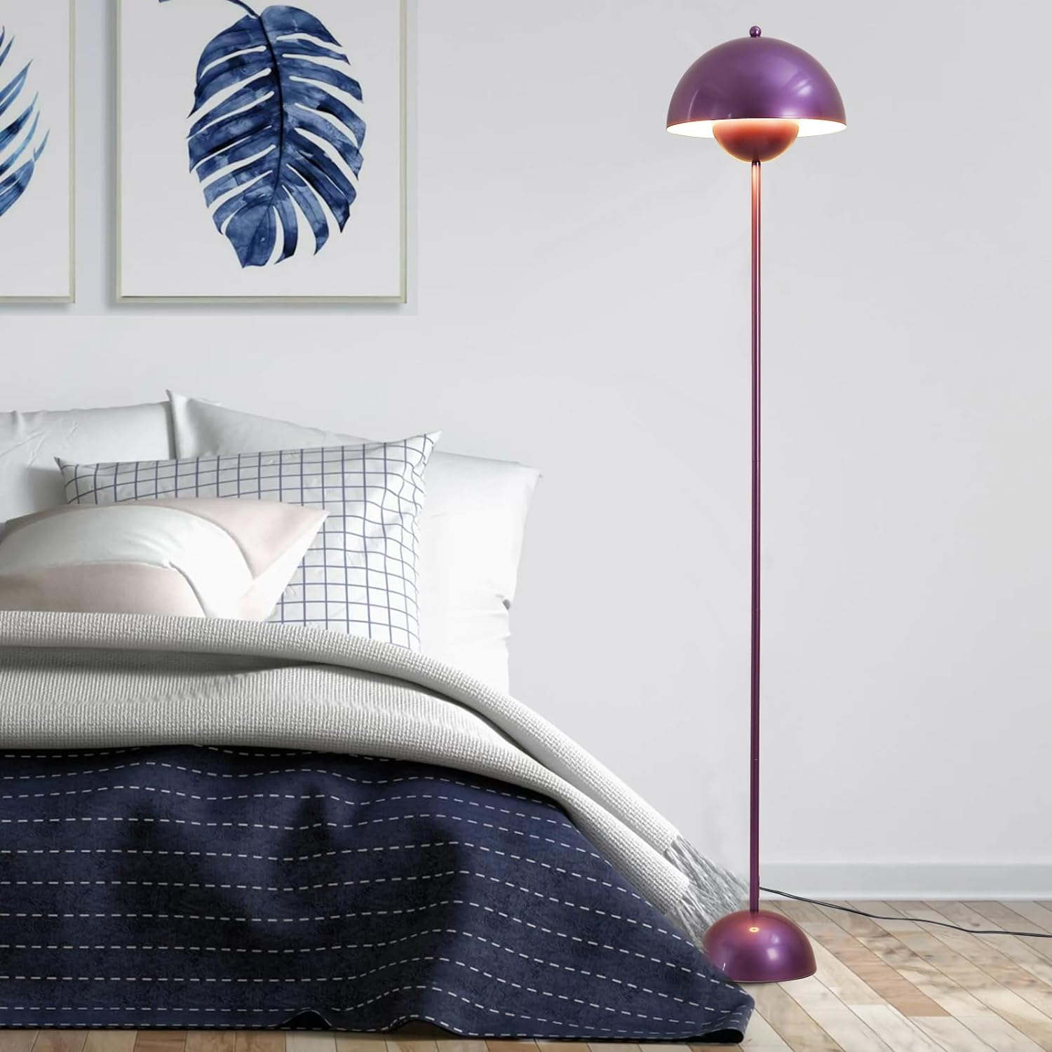 Una lámpara de pie morada junto a una cama en un dormitorio.