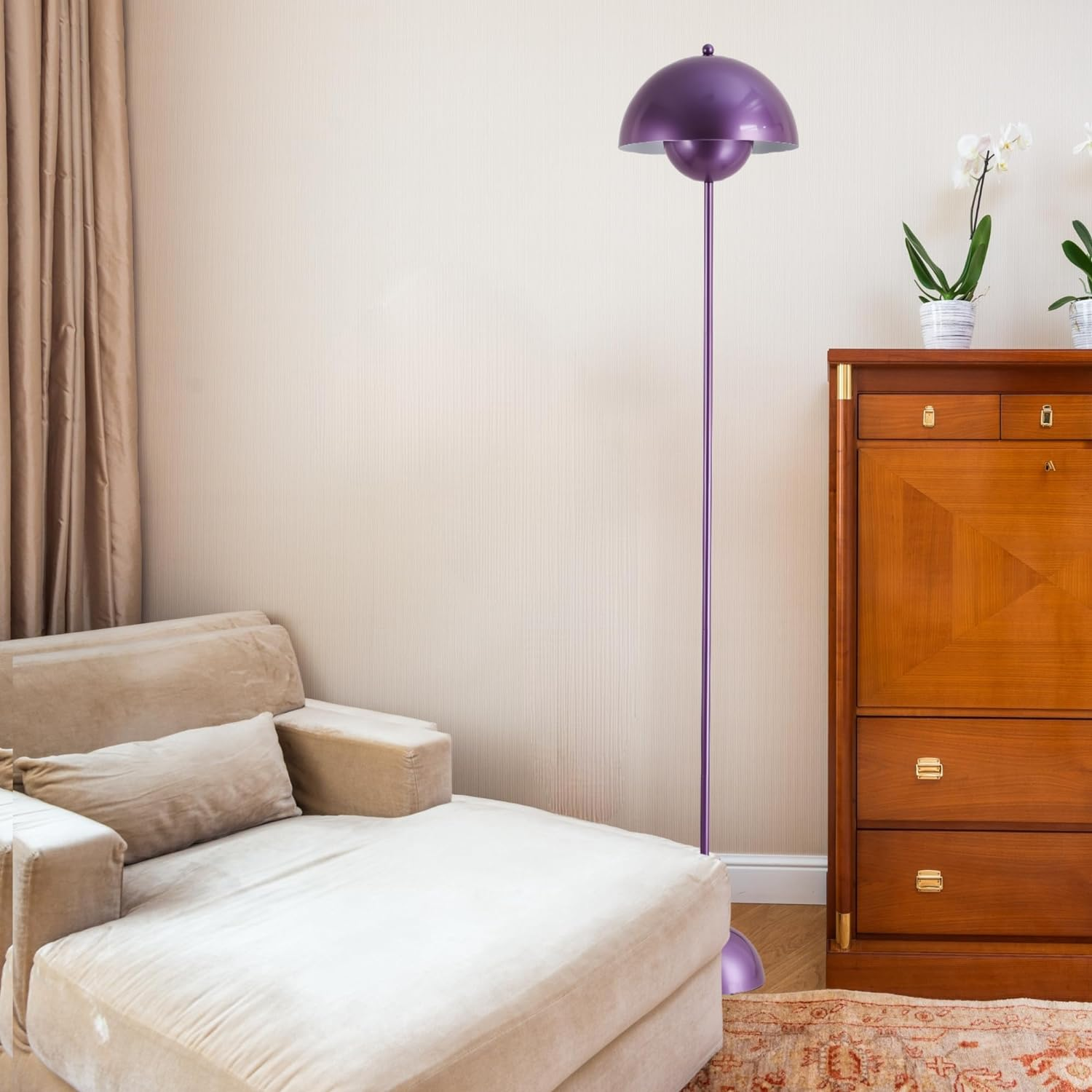 Una lámpara de pie morada junto a una silla beige y un armario de madera.