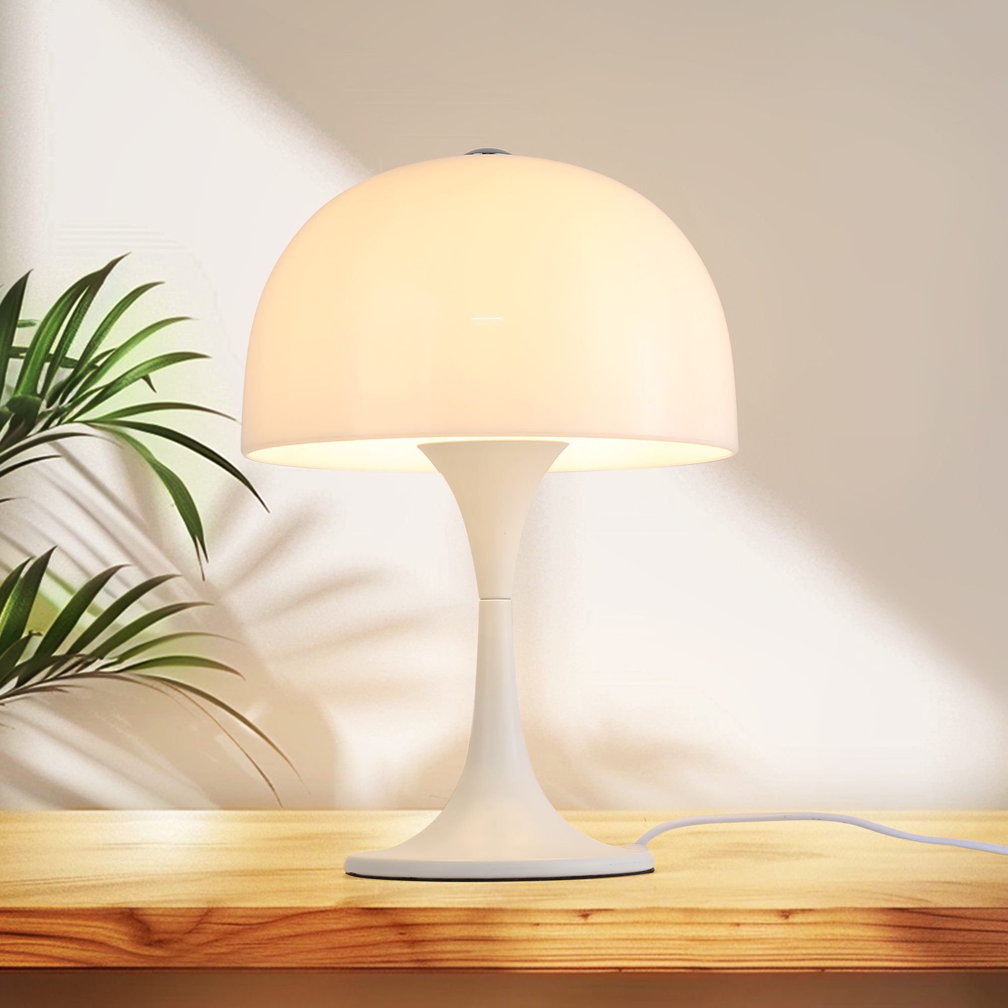 Una lámpara blanca con pantalla iluminada sobre una mesa de madera.
