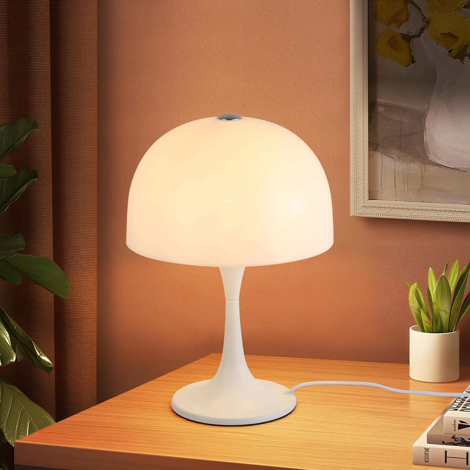 Lámpara blanca con pantalla redonda sobre mesa de madera. La luz está encendida.