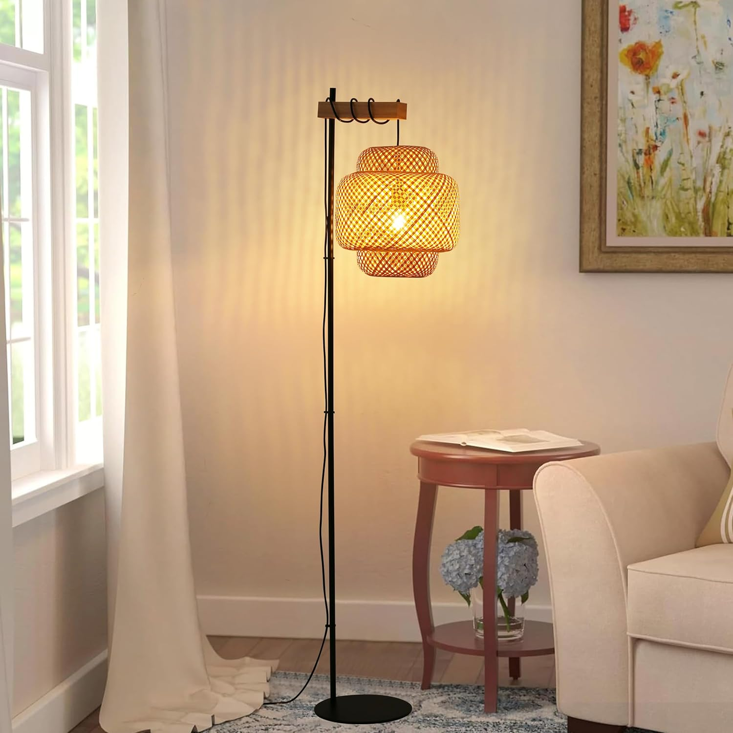 Una lámpara de pie con pantalla tejida. La lámpara está en una habitación con una ventana y una pintura.