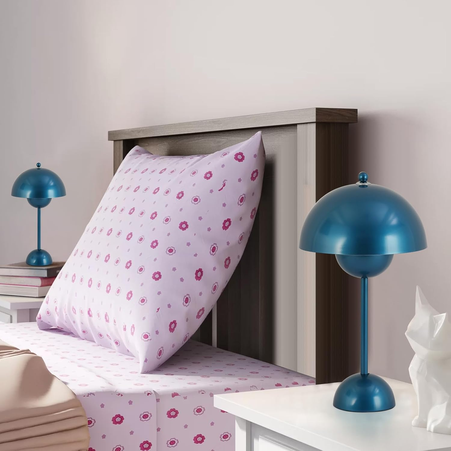 Escena de dormitorio con cama, almohada y dos lámparas azules en las mesitas.