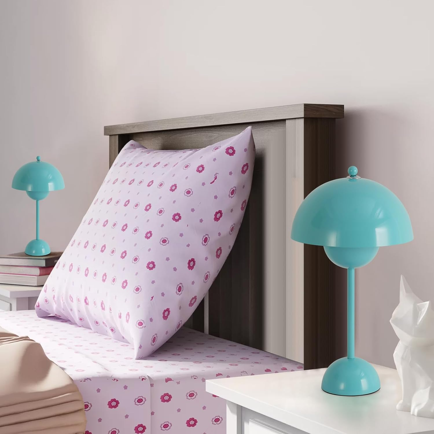 Escena de dormitorio con cama, almohada y dos lámparas de escritorio azules en las mesitas de noche. Figura blanca.
