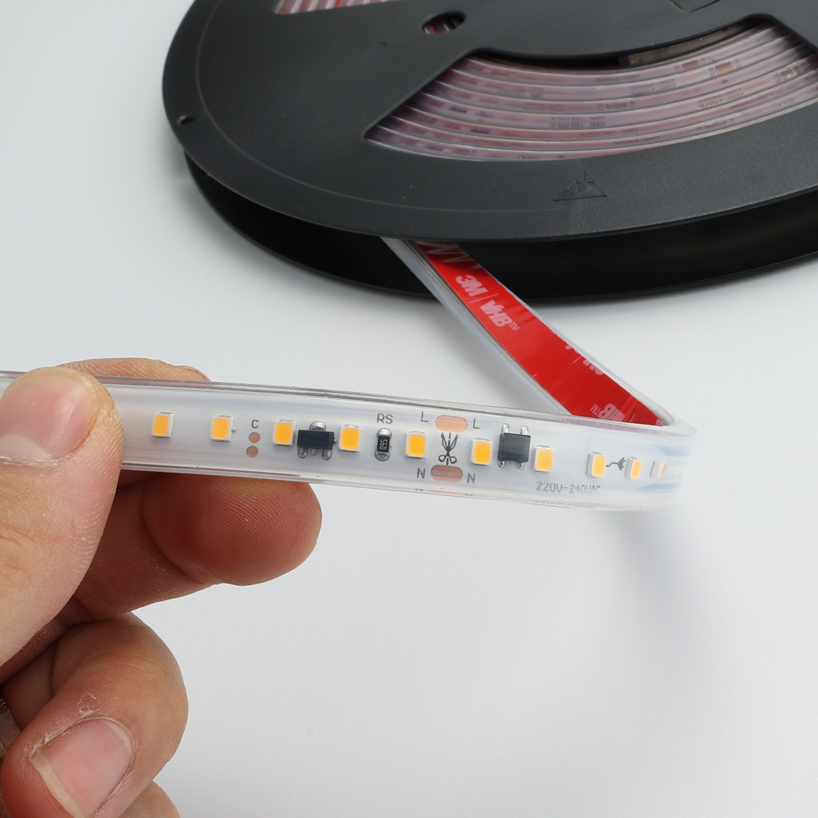 Primer plano de una tira LED con diodos visibles. Una mano sostiene la tira.