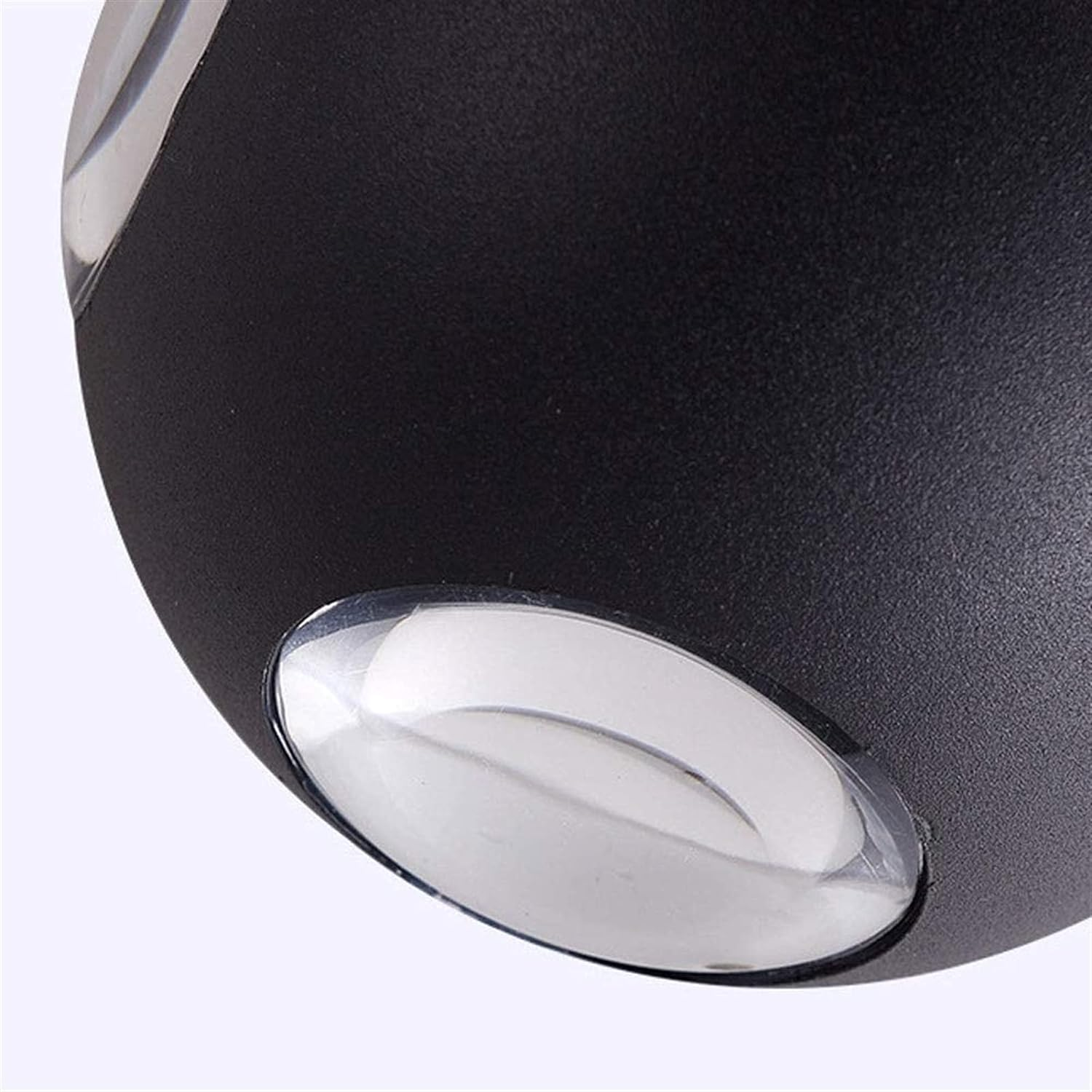 Primer plano de una lámpara de pared negra con dos luces. Las luces son plateadas. El fondo es blanco.