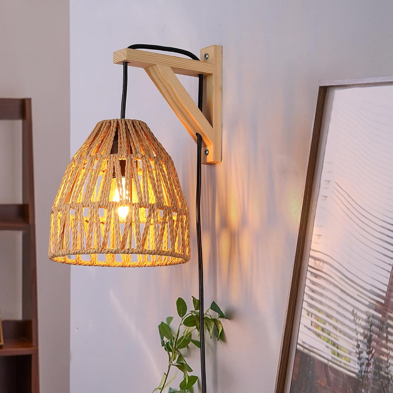 Lámpara de pared con pantalla tejida y soporte de madera. Cable de alimentación negro visible.