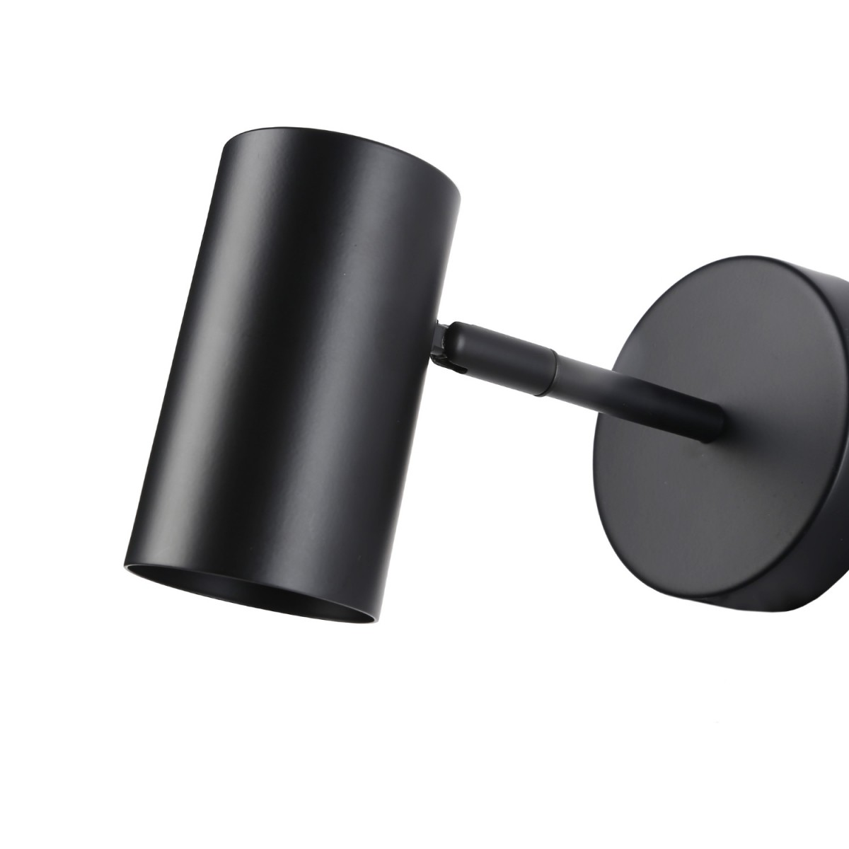 Lámpara de pared negra con cabezal cilíndrico y base circular, ligeramente inclinada a la izquierda.