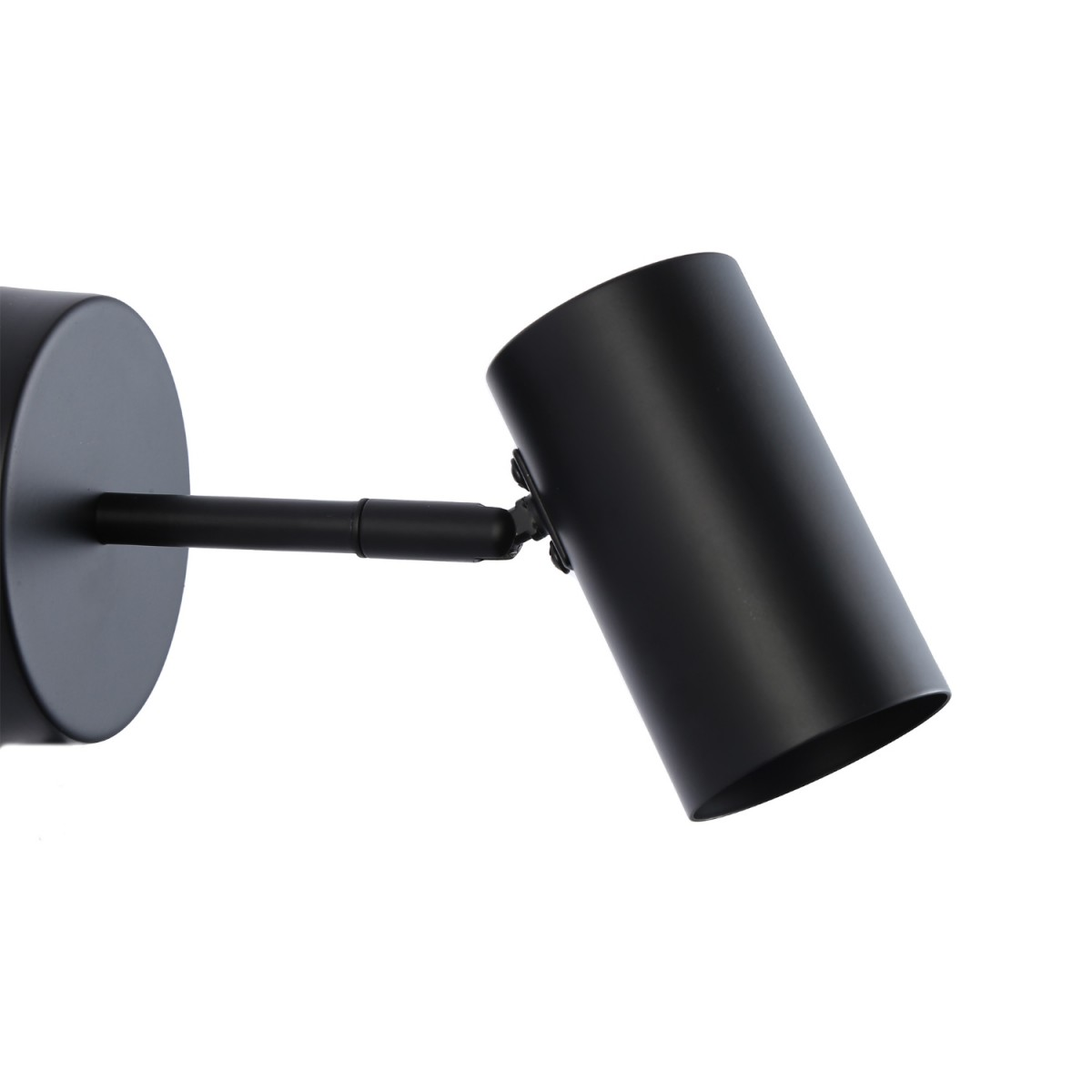 Foco negro montado en la pared. Tiene una base circular y un cabezal de luz cilíndrico ajustable, inclinado hacia la derecha.