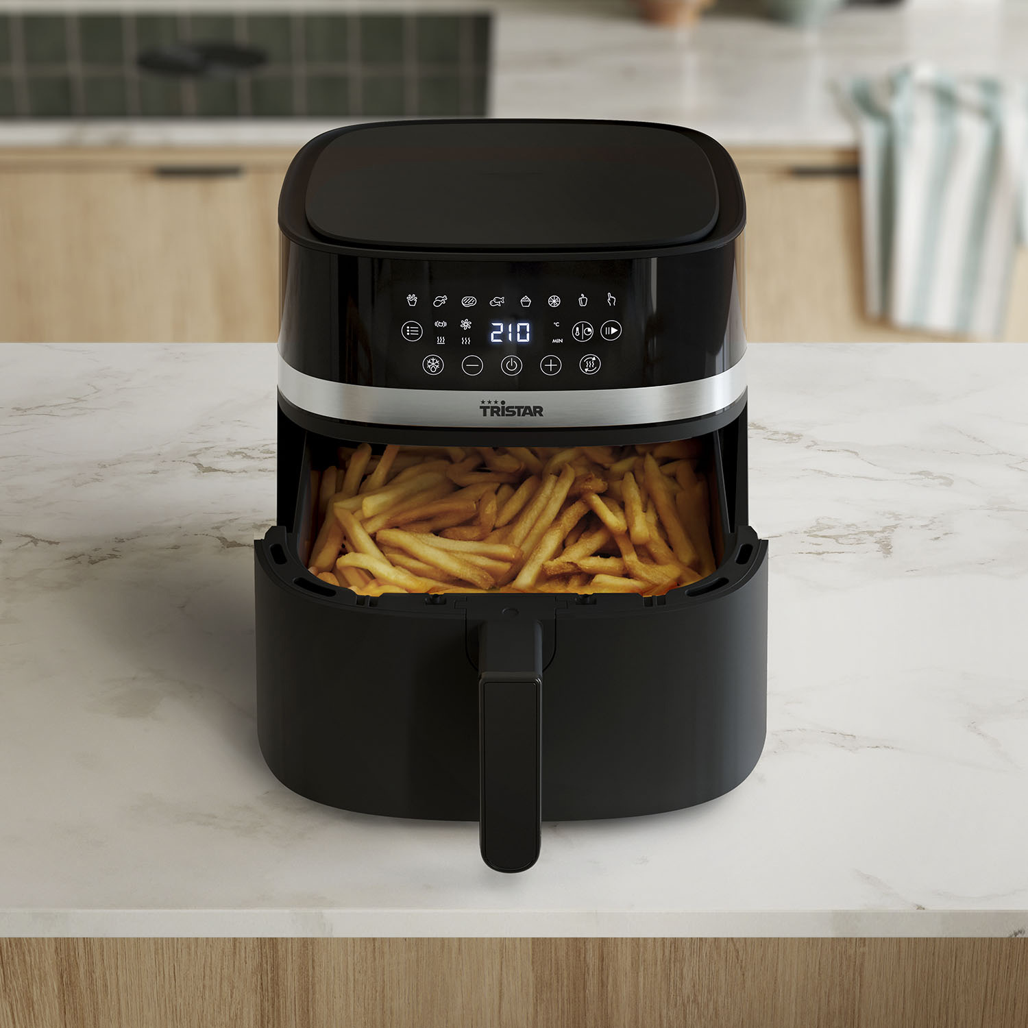 Zwarte airfryer met frietjes erin.