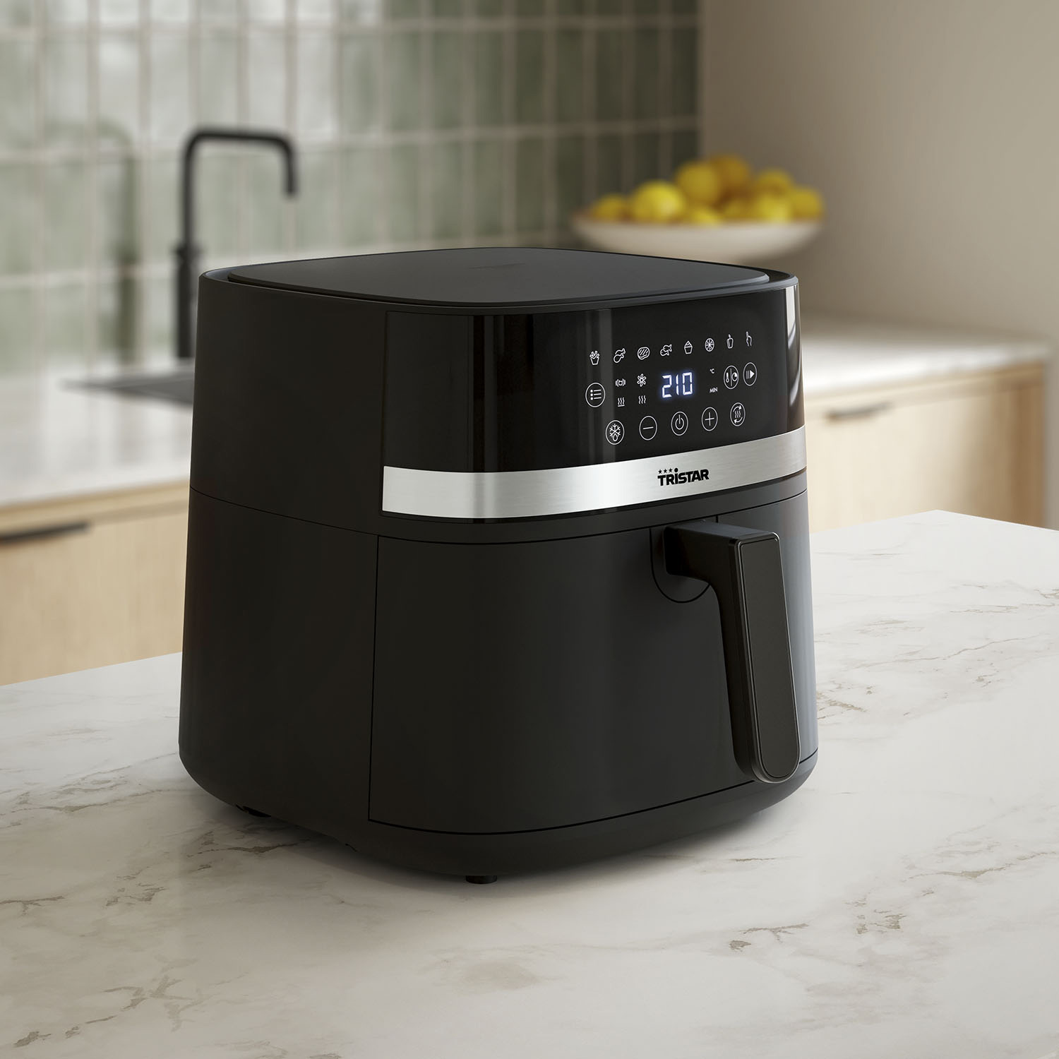 Zwarte airfryer op een wit aanrecht. Keukenomgeving, met een gootsteen op de achtergrond.