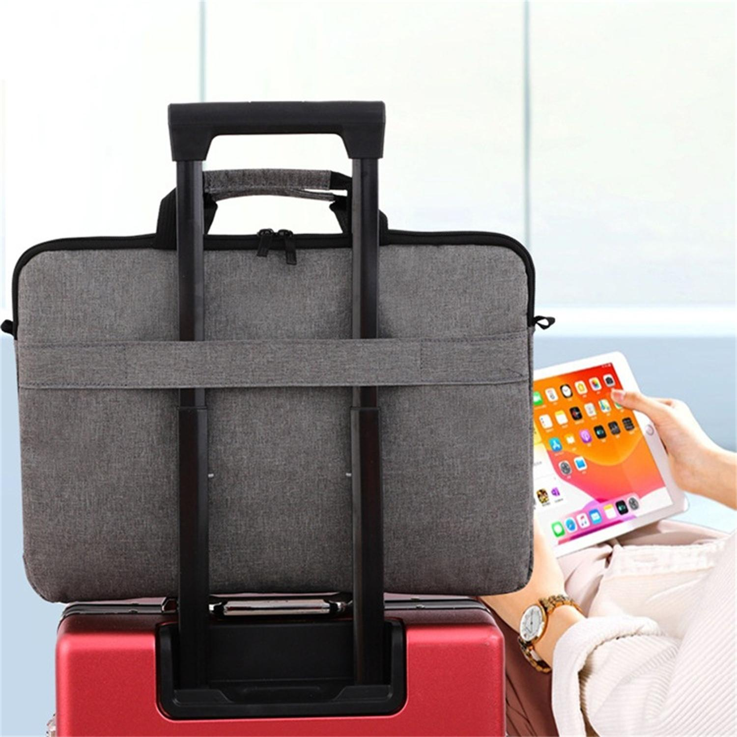 Laptoptasche auf einem Koffer. Eine Person benutzt ein Tablet neben dem Koffer. Graue Tasche auf rotem Koffer.
