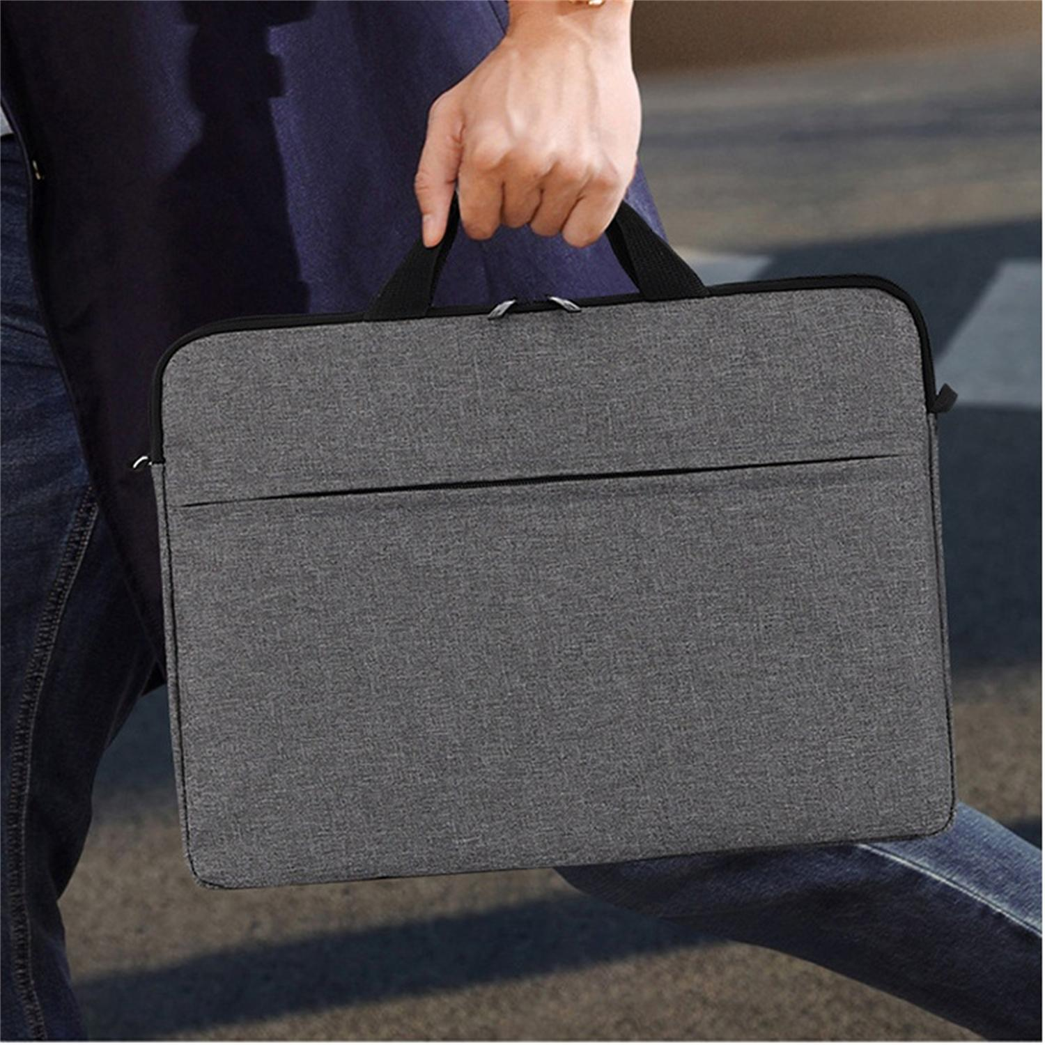 Eine Person, die eine graue Laptop-Tasche mit schwarzen Griffen hält, geht mit verschwommenem Hintergrund.