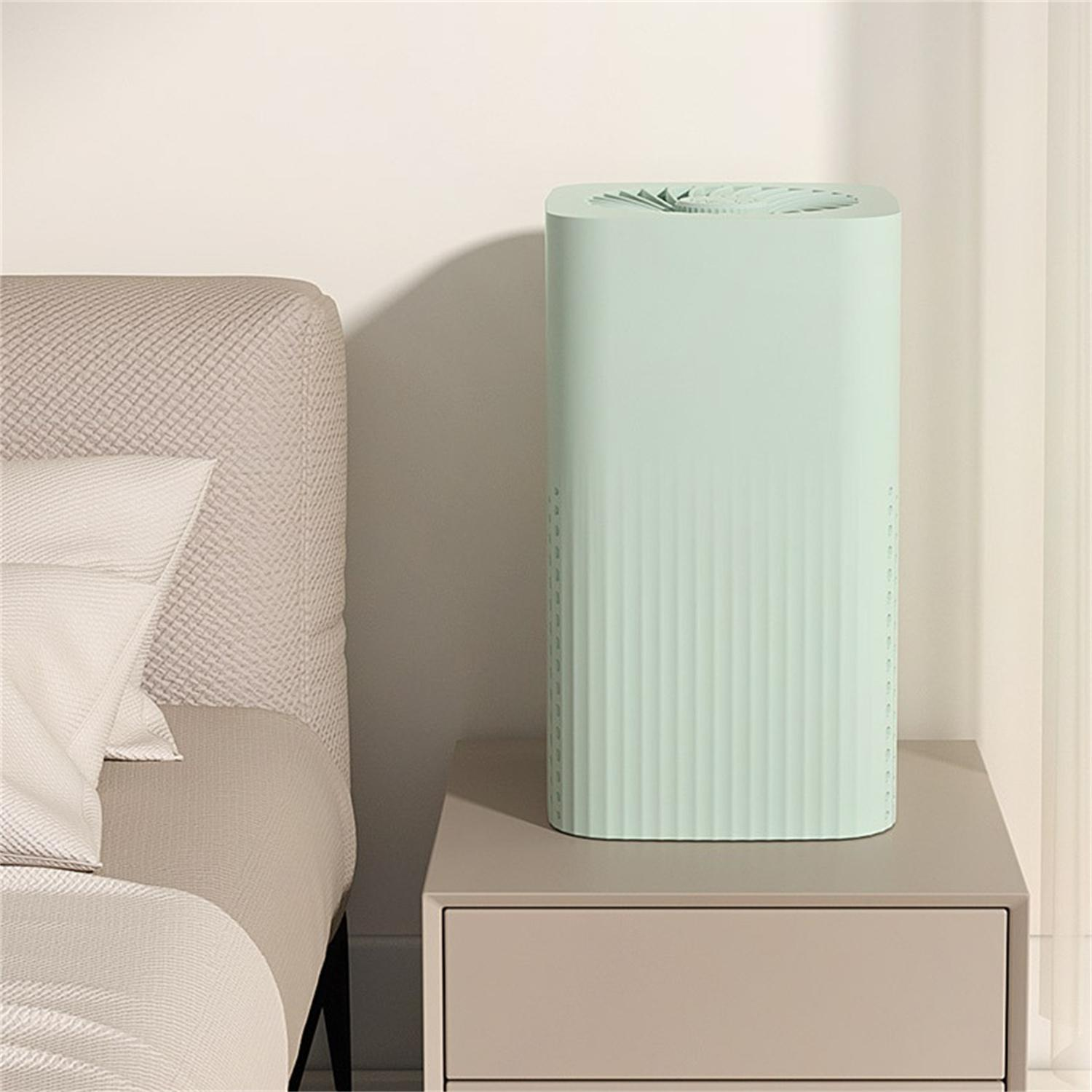 Ein grüner Luftreiniger auf einem Tisch. Der Reiniger ist ein vertikales Rechteck mit einem Ventilator oben.