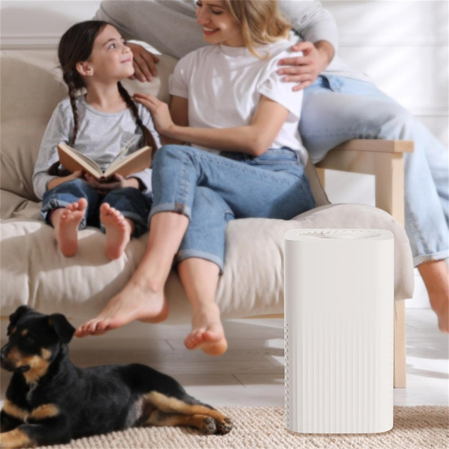 Eine Familie sitzt mit einem Hund auf einem Sofa. Ein weißer Luftreiniger steht neben dem Sofa.