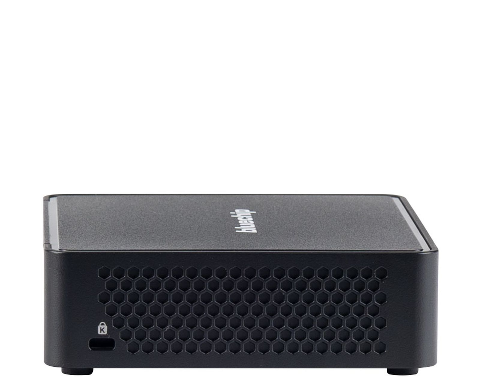Piccolo computer nero con ventola a nido d'ape e porte sul retro, su una superficie bianca.