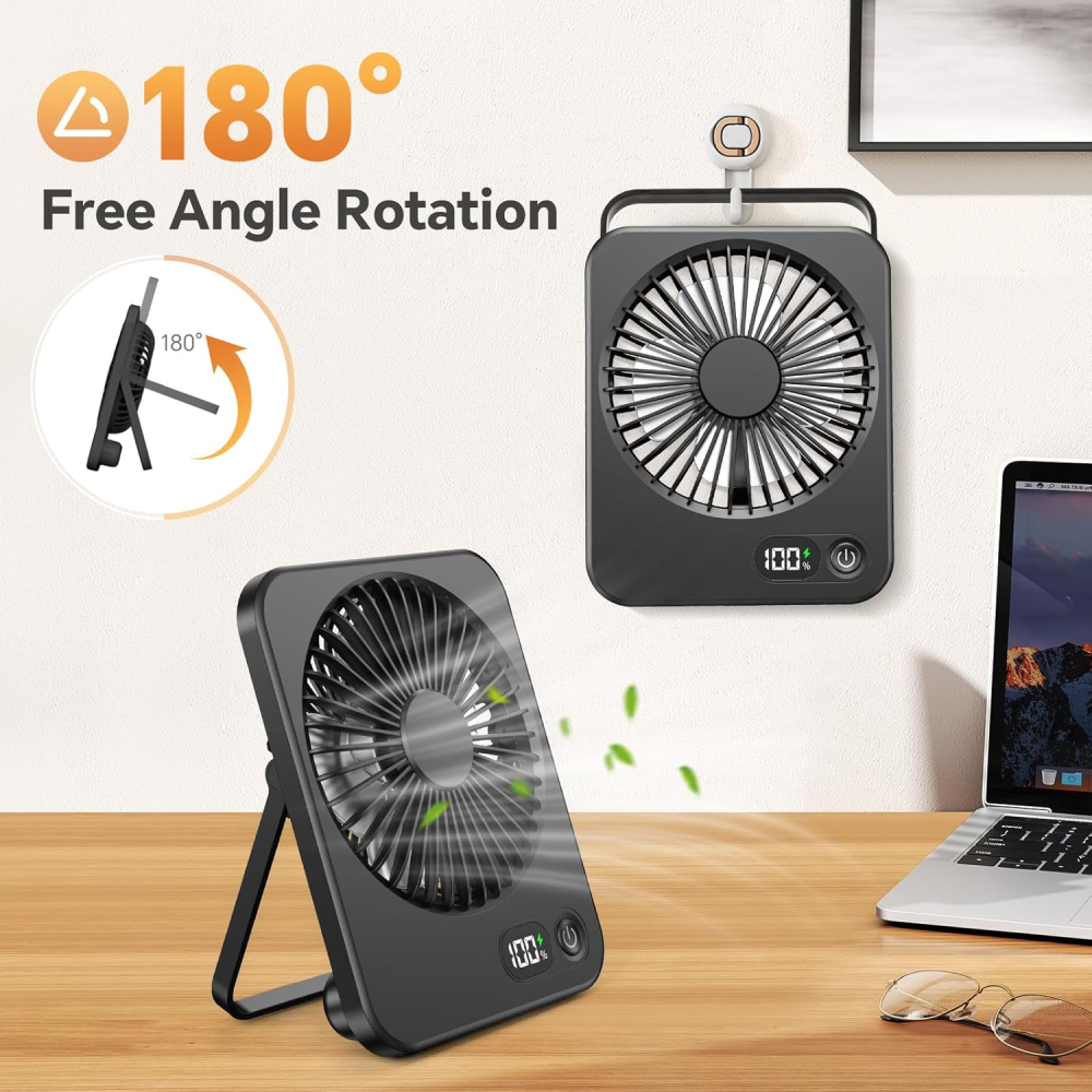 Schwarzer Ventilator auf einem Schreibtisch, mit 180-Grad-Drehung. Laptop und Brille sind sichtbar, mit grünen Blättern.
