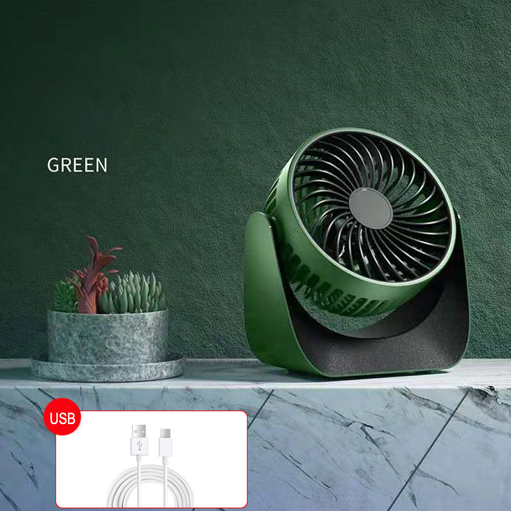 Grüner Ventilator auf einer Oberfläche mit Pflanze und USB-Kabel. Dunkelgrüner Hintergrund.