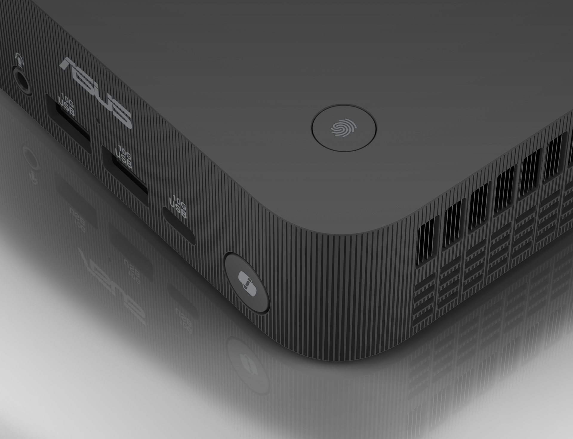 Close-up of a black computer. The corner has ports and a fingerprint sensor. The surface is grooved. 