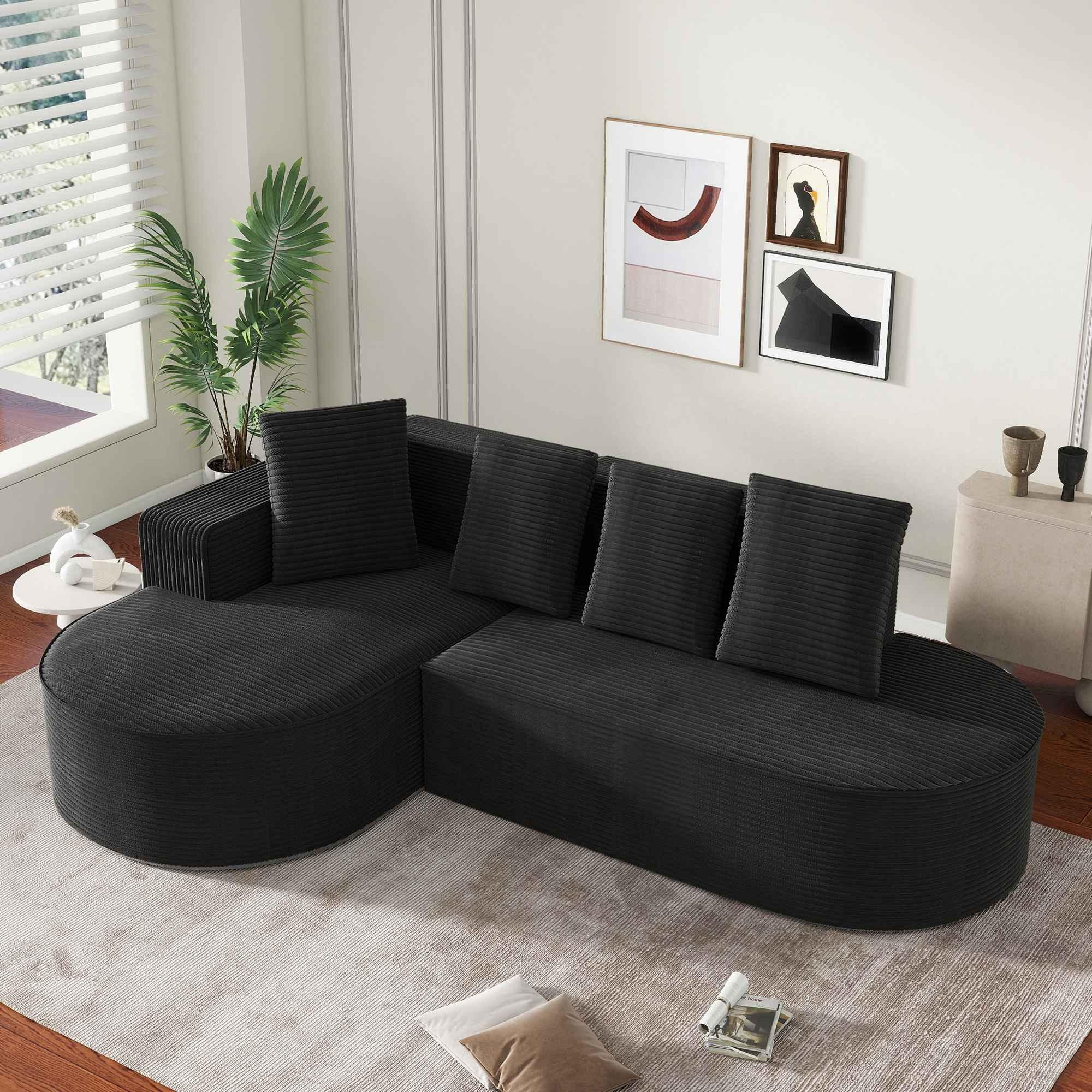 Schwarzes Ecksofa mit Kissen, auf einem Teppich. Modernes Design, mit geschwungener Form, in einem Raum aufgestellt.