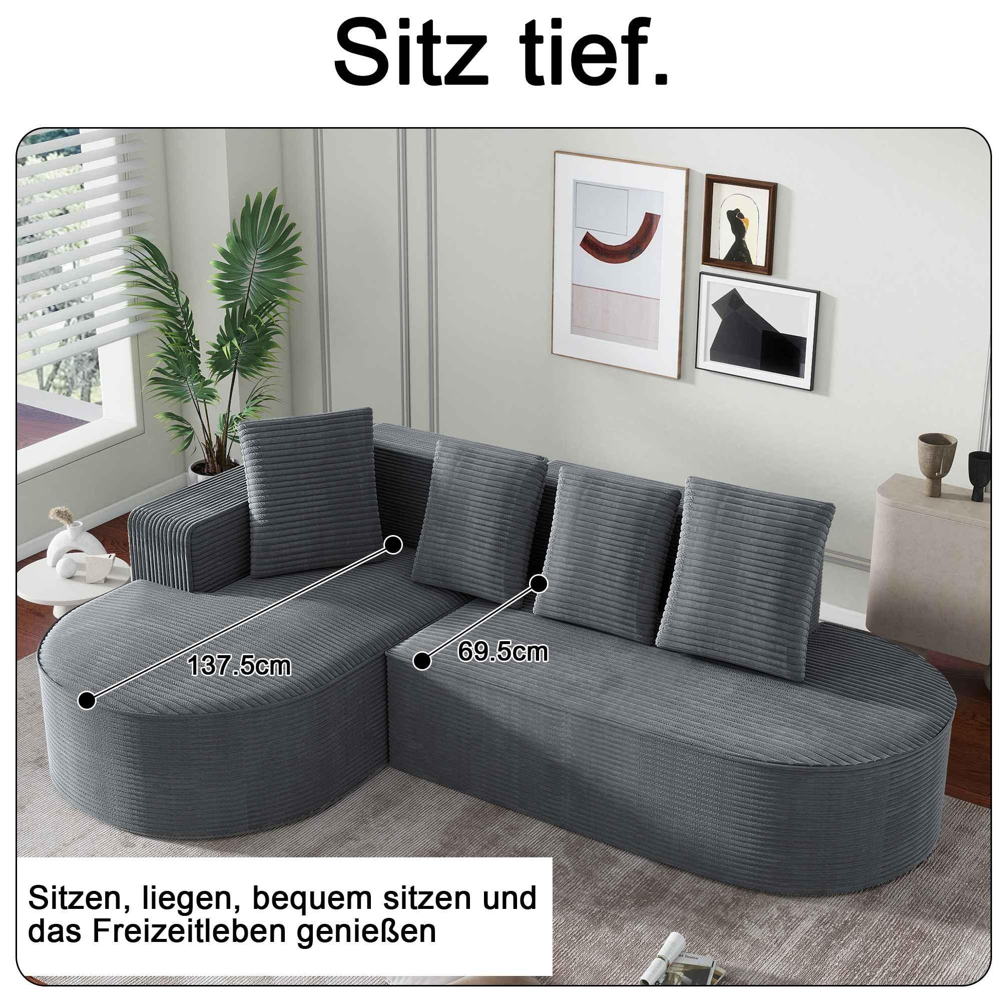 Ein graues Ecksofa mit Kissen. Es steht in einem Raum mit Bildern an der Wand. Das Sofa ist Cord.