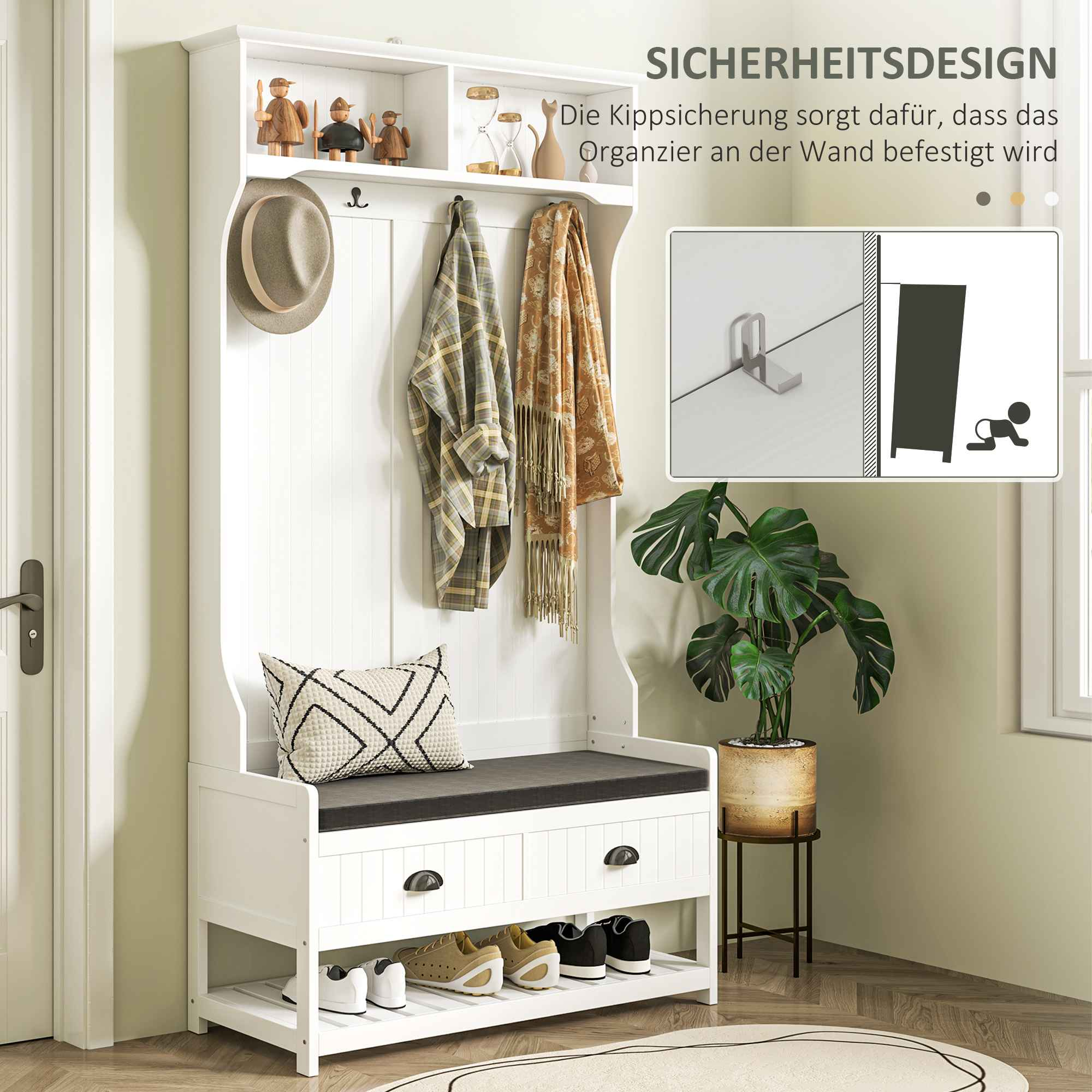 Weiße Eingangsbank mit Haken, Regalen und Schubladen. Schuhe im unteren Regal. Dekoration oben.