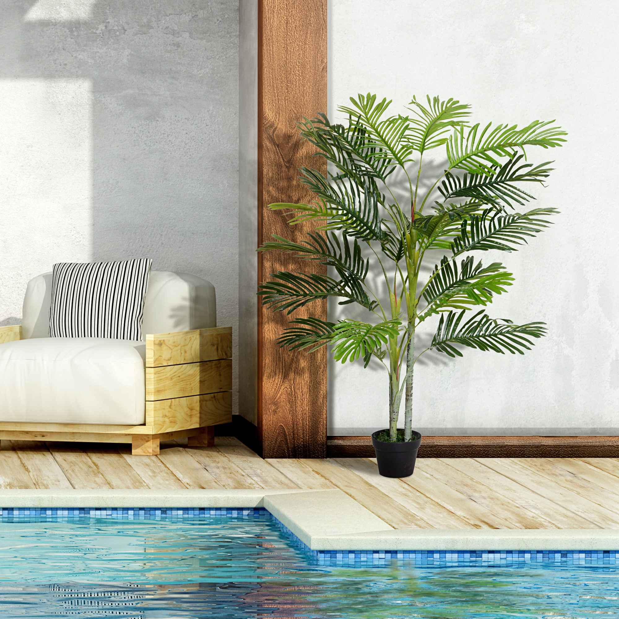 Palme in einem schwarzen Topf auf einem Holzdeck in der Nähe eines Pools. Ein weißer Stuhl im Hintergrund.
