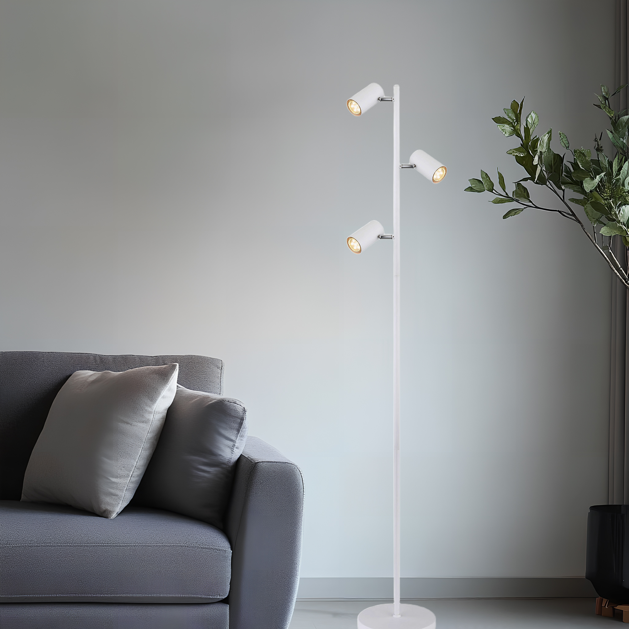Eine moderne weiße Stehlampe mit drei verstellbaren Strahlern, in der Nähe eines grauen Sofas positioniert.