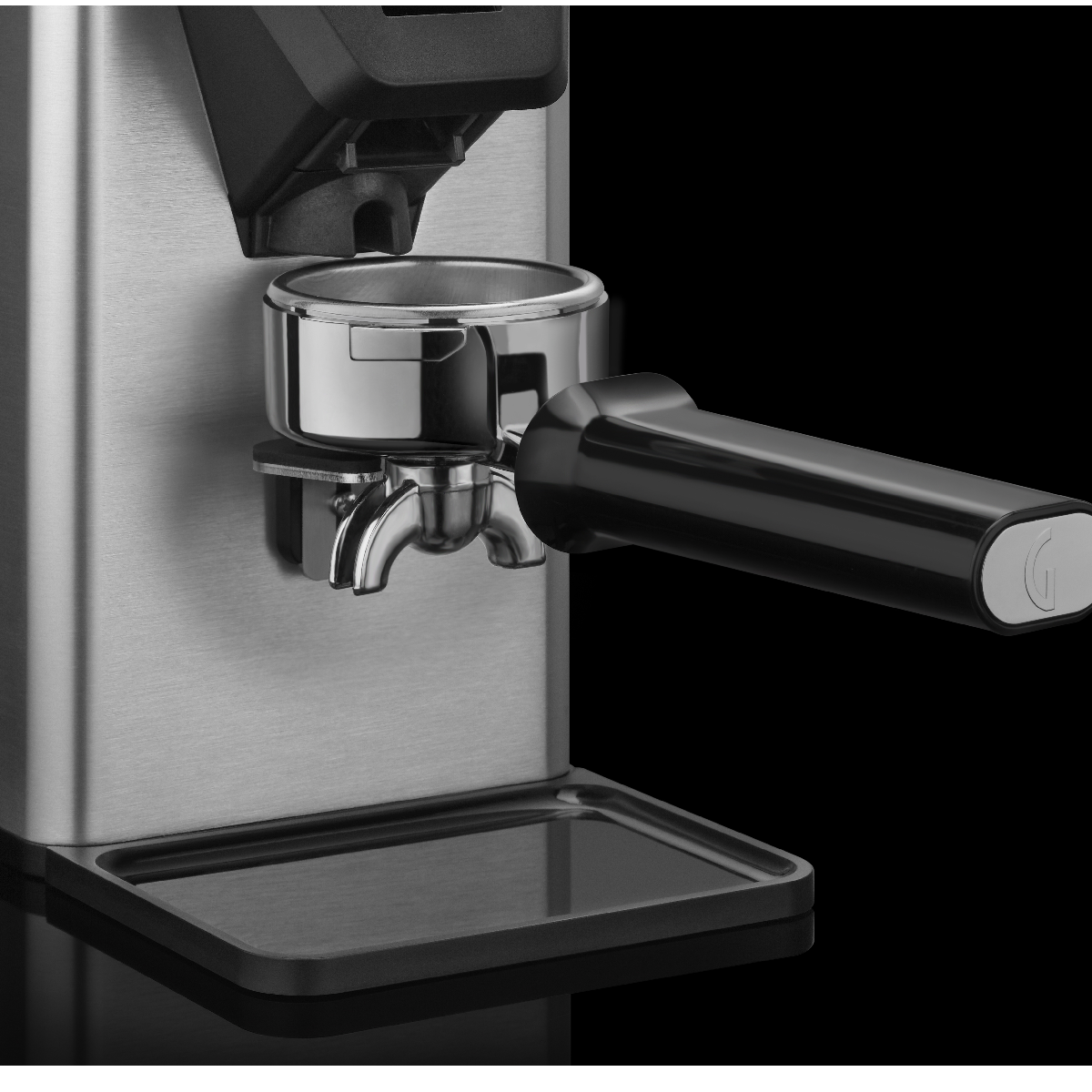 Eine Kaffeemühle mit angebrachtem Siebträger. Die Mühle ist silber und schwarz, der Siebträger ist schwarz. Schwarzer Hintergrund.