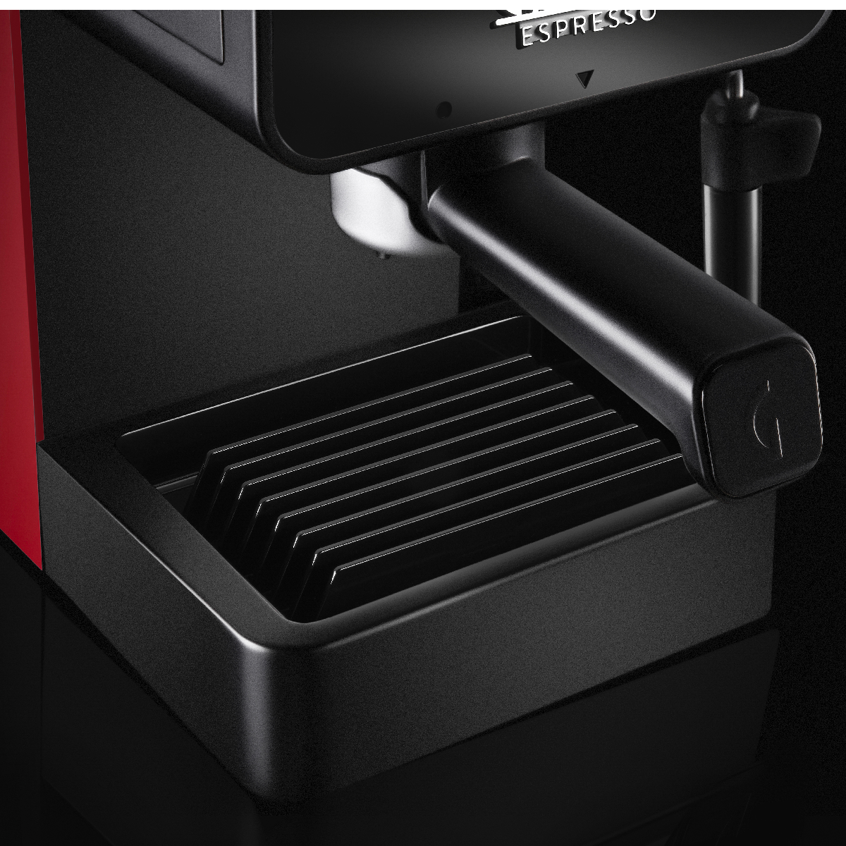 Zbliżenie czerwono-czarnego ekspresu do kawy. Widoczna tacka na wodę i wylewka do espresso.