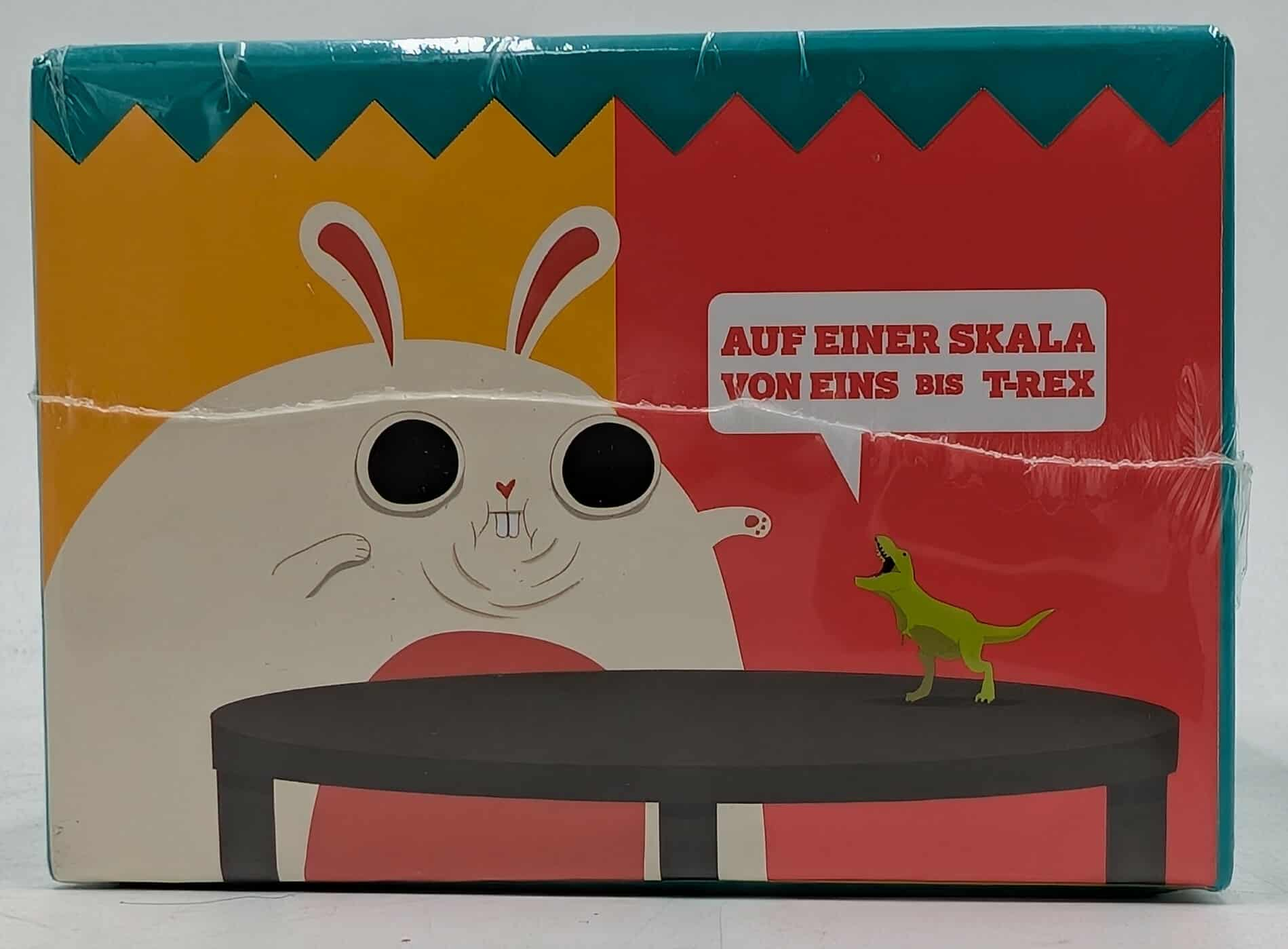 Spielbox mit Kaninchen und kleinem T-Rex. Text: 'Auf einer Skala von Eins bis T-Rex'.
