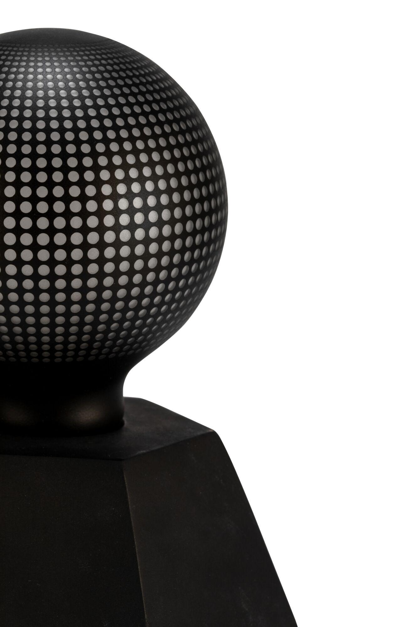 Czarna, okrągła lampa z białymi kropkami i białym tłem.