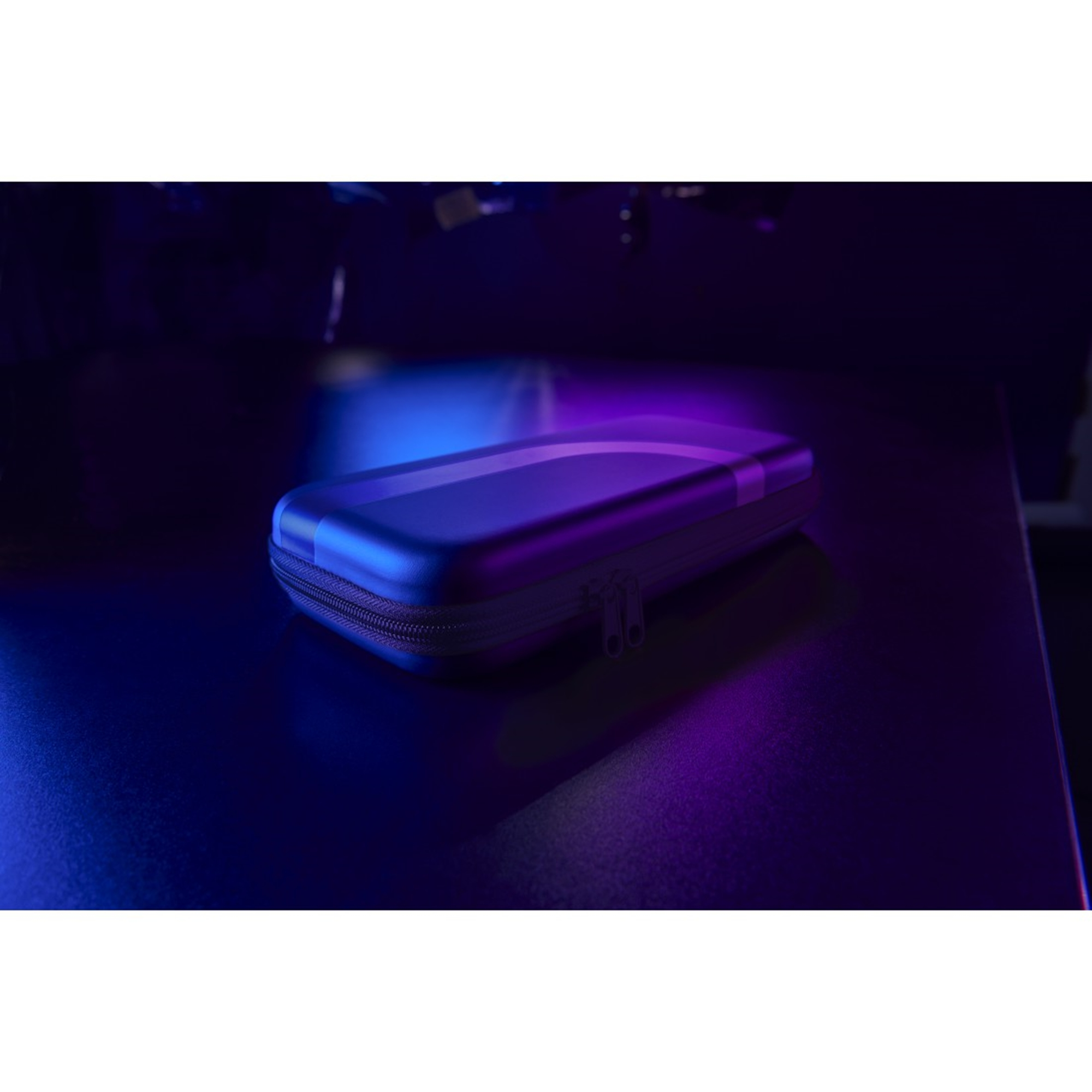 Ein geschlossener Koffer auf einem Tisch, blaue und violette Beleuchtung, Reißverschluss sichtbar.