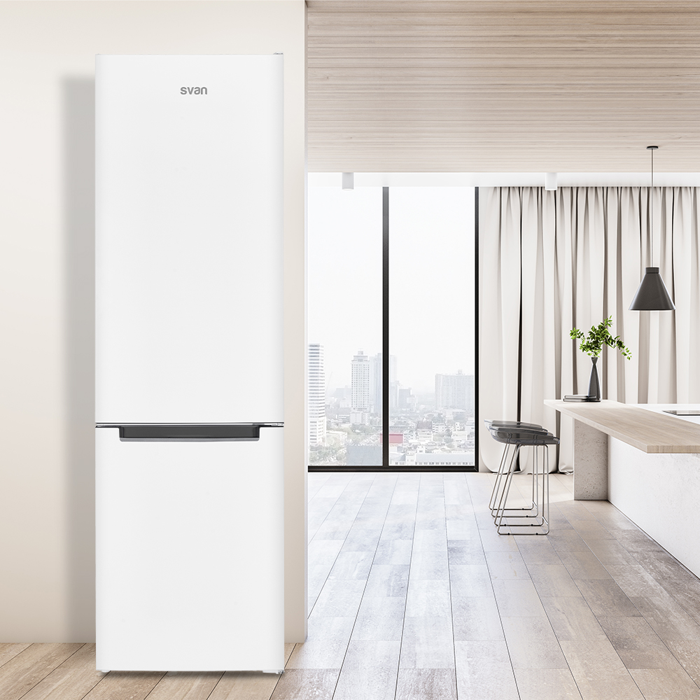 Un refrigerador blanco está en una habitación moderna. La habitación tiene una ventana grande, una encimera de madera y un taburete.