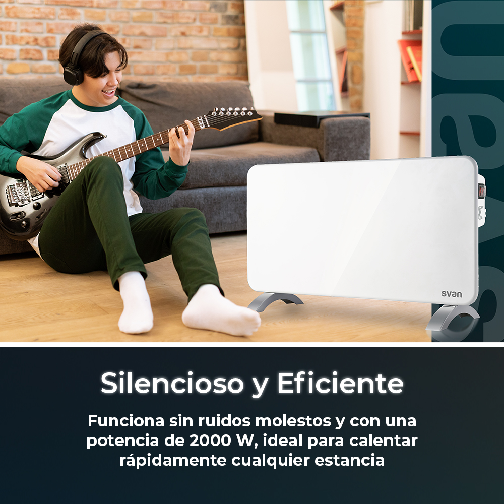 Joven toca la guitarra frente a un calefactor blanco. Lleva auriculares. Sofá gris detrás.
