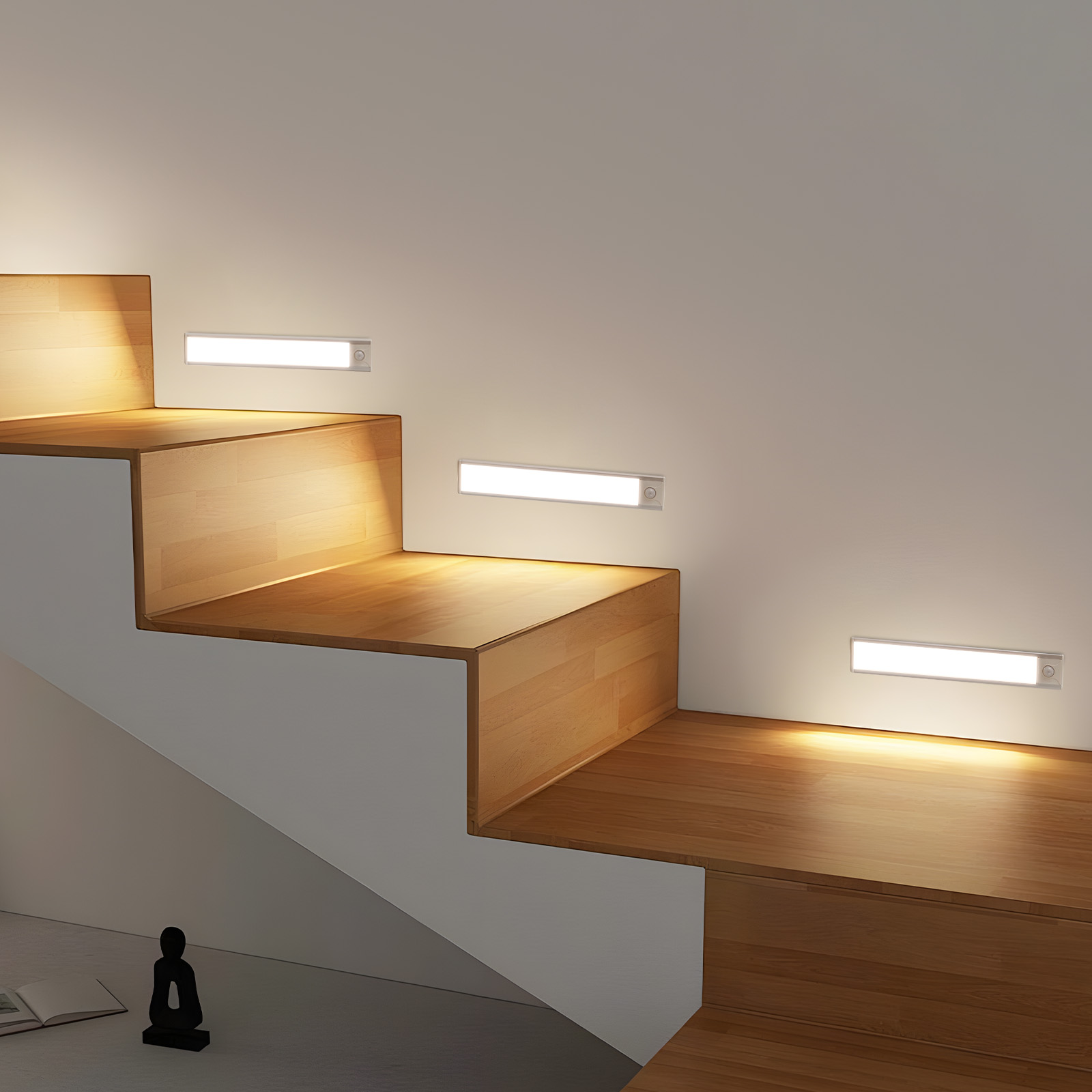 Scale in legno con luci rettangolari integrate sulle pareti laterali. La luce calda illumina i gradini.