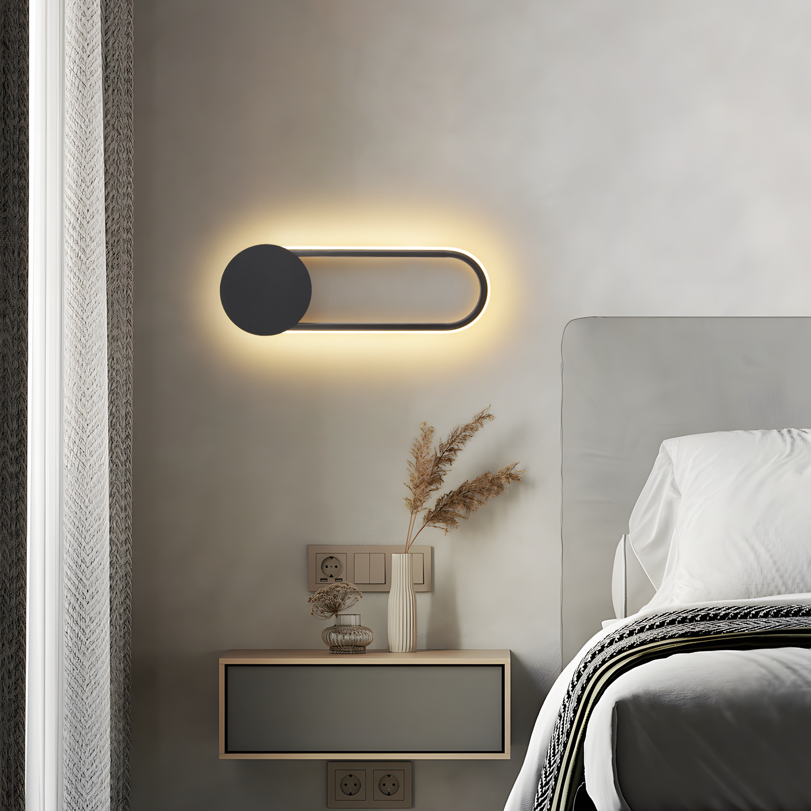 Camera da letto moderna con una lampada da parete sopra un comodino. La luce è nera con forma allungata bianca.