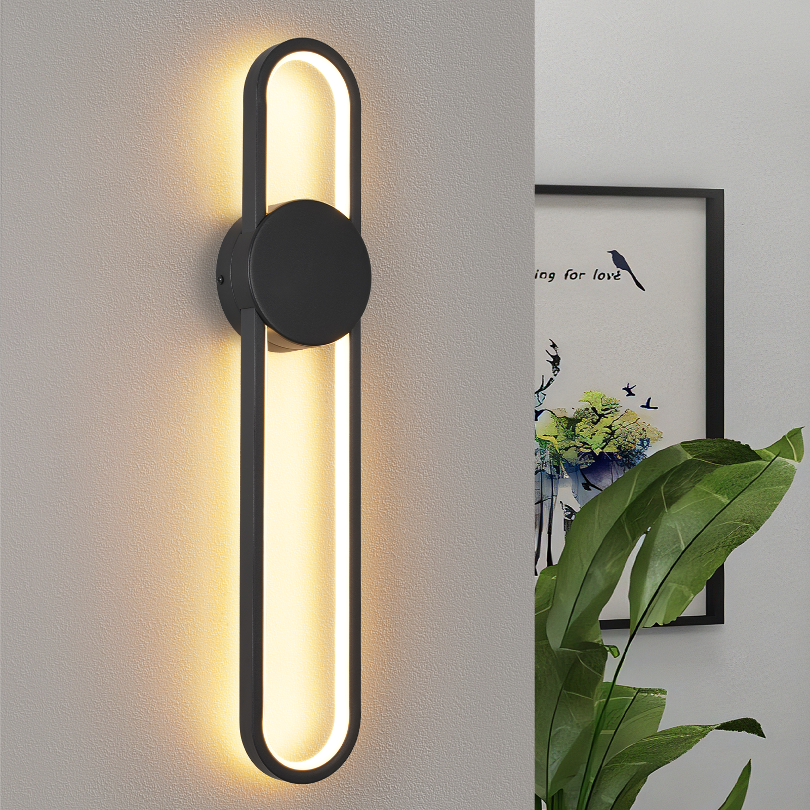 Lampada da parete con design nero circolare e allungato. Una pianta e un'opera d'arte sullo sfondo.