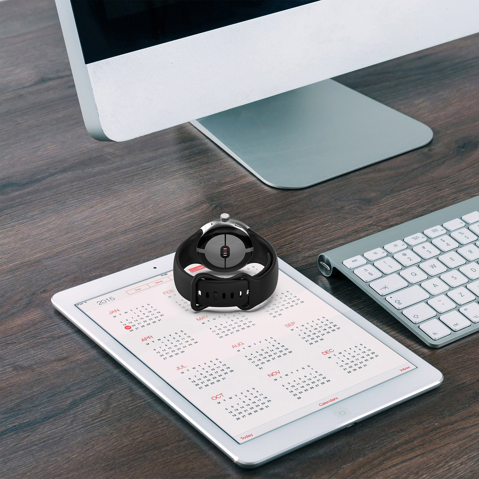 Eine Uhr auf einem Tablet, das einen Kalender anzeigt. Die Uhr ist schwarz, auf weißem Hintergrund.