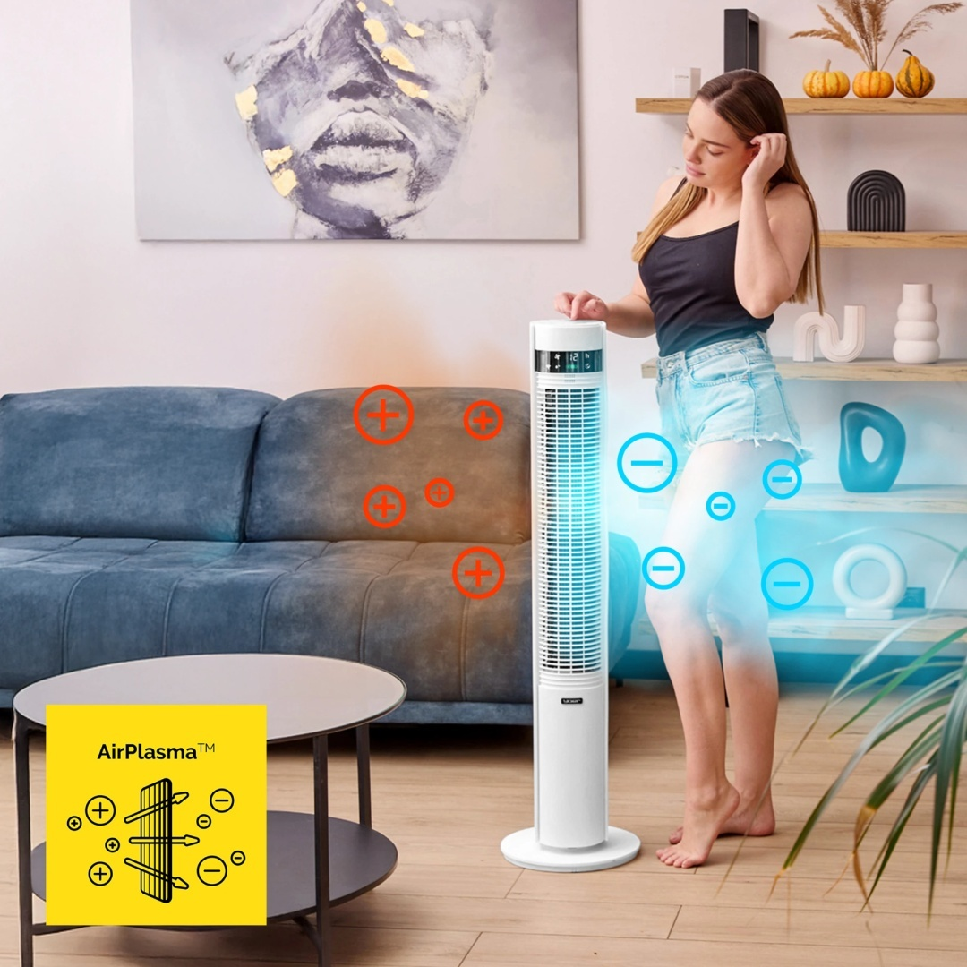 Kobieta w salonie z wentylatorem. Wentylator wyświetla AirPlasma, a kobieta jest w pobliżu wentylatora.