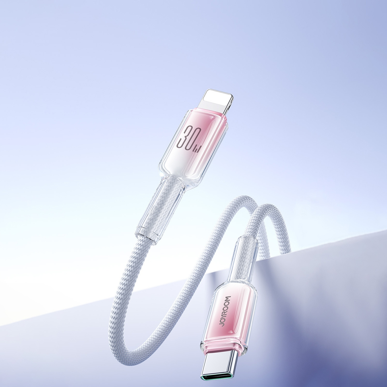 Ein weißes Ladekabel mit rosa Akzenten vor blauem Hintergrund.