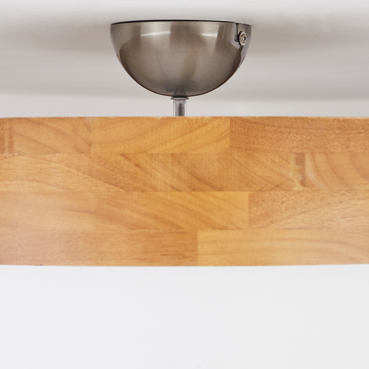 Nahaufnahme einer Deckenleuchtenbefestigung. Sie hat ein Holzelement und Metallteile. Weißer Hintergrund.