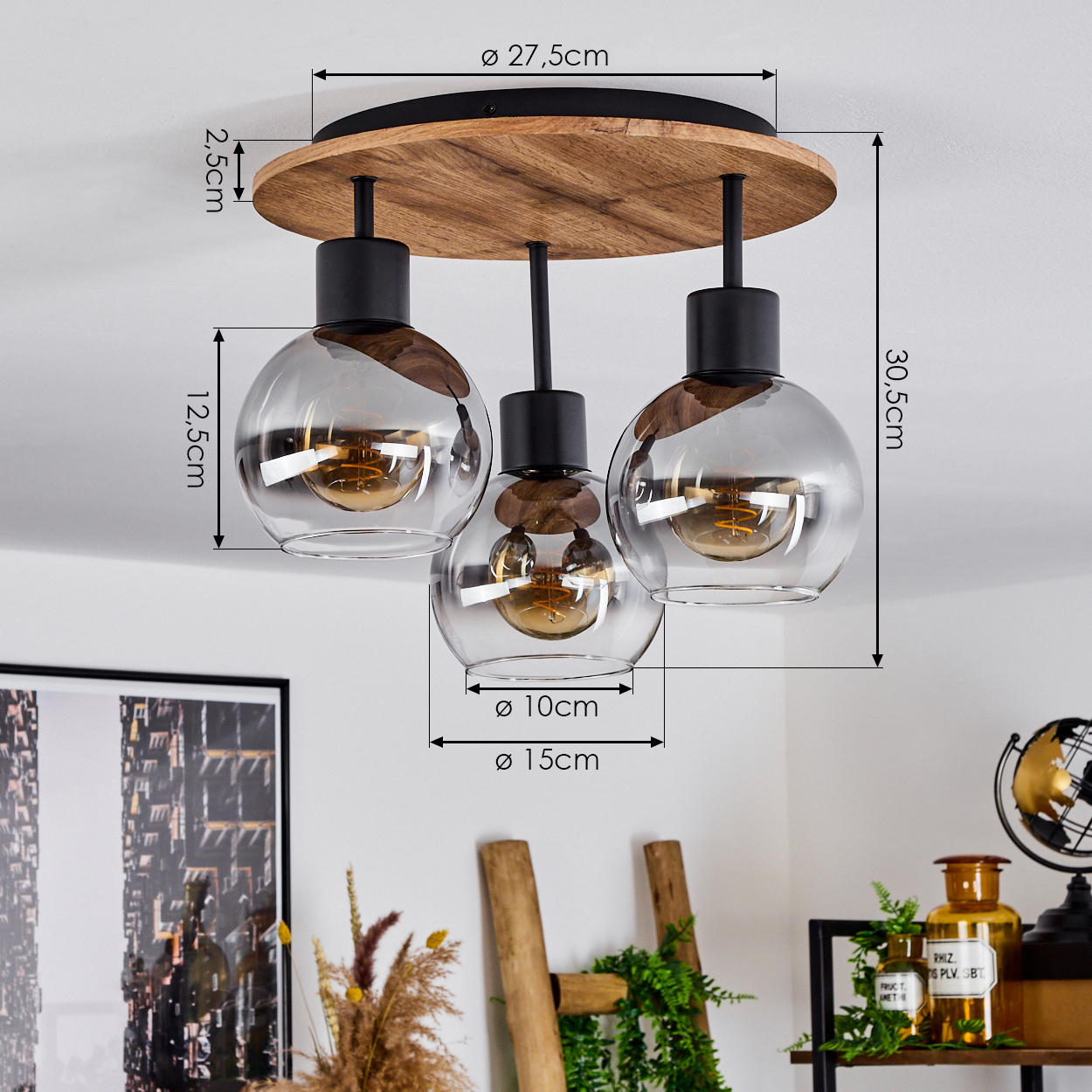 Deckenlampe mit drei Glaskugel-Schirmen, Holzsockel und Dekoration in einem Raum. Die Lampe ist der Fokus.