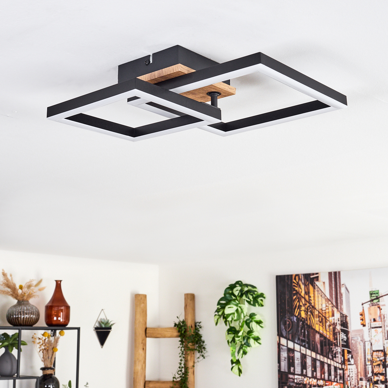 Deckenleuchte mit mehreren quadratischen Lichtelementen, Holzsockel und Dekoration in einem Raum.