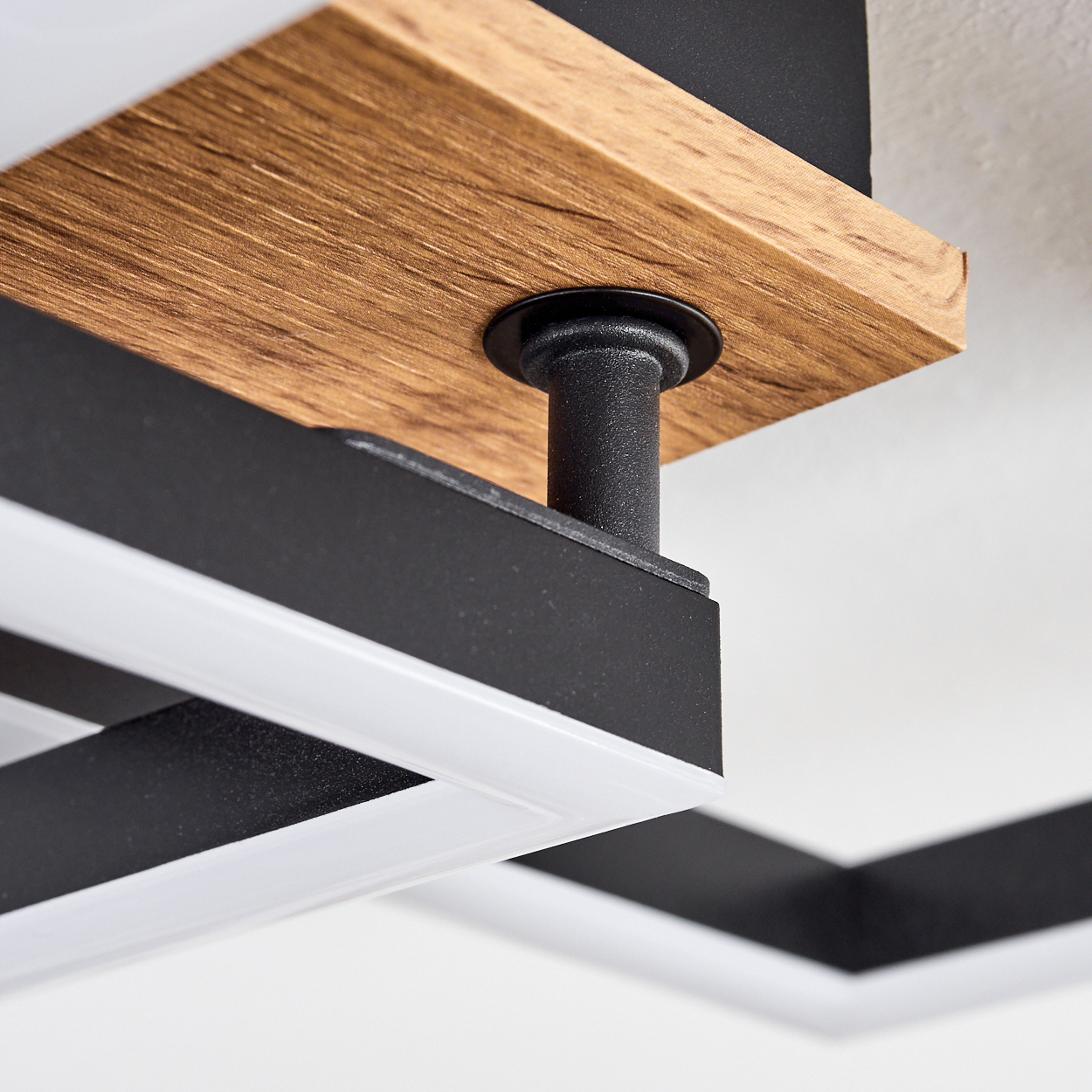 Nahaufnahme einer Deckenleuchte mit Holz- und schwarzer Konstruktion.