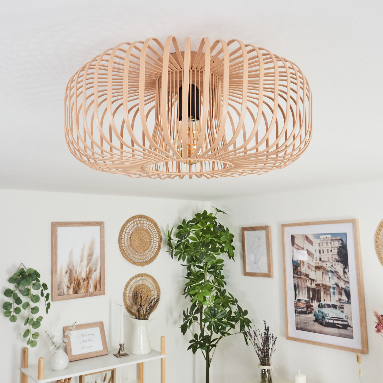 Eine Leuchte aus beigen, gebogenen Holzlatten mit Glühbirne, an einer weißen Decke montiert.